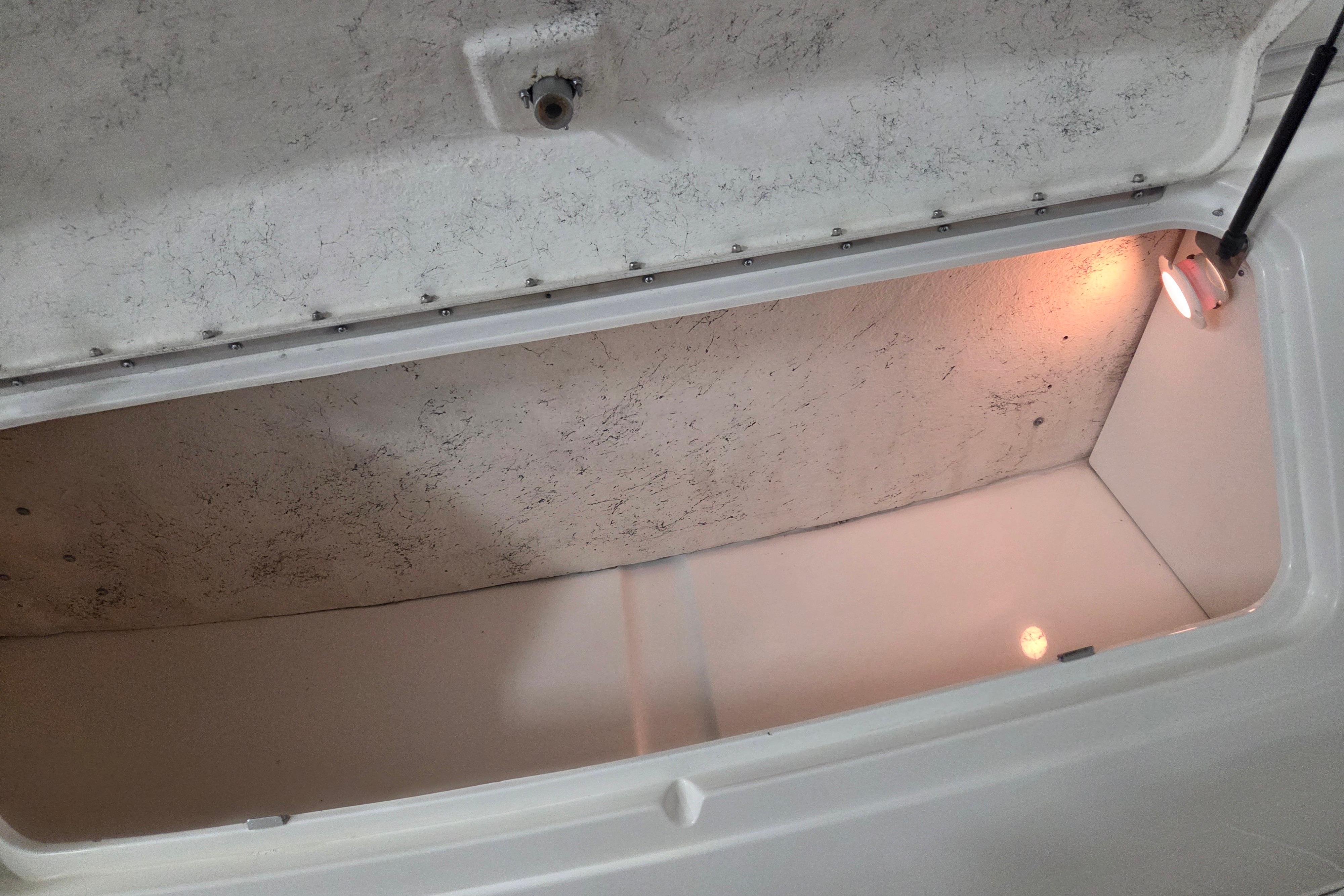 Open storage compartment with light inside a 2000 Sea Ray Sundancer 540 boat.