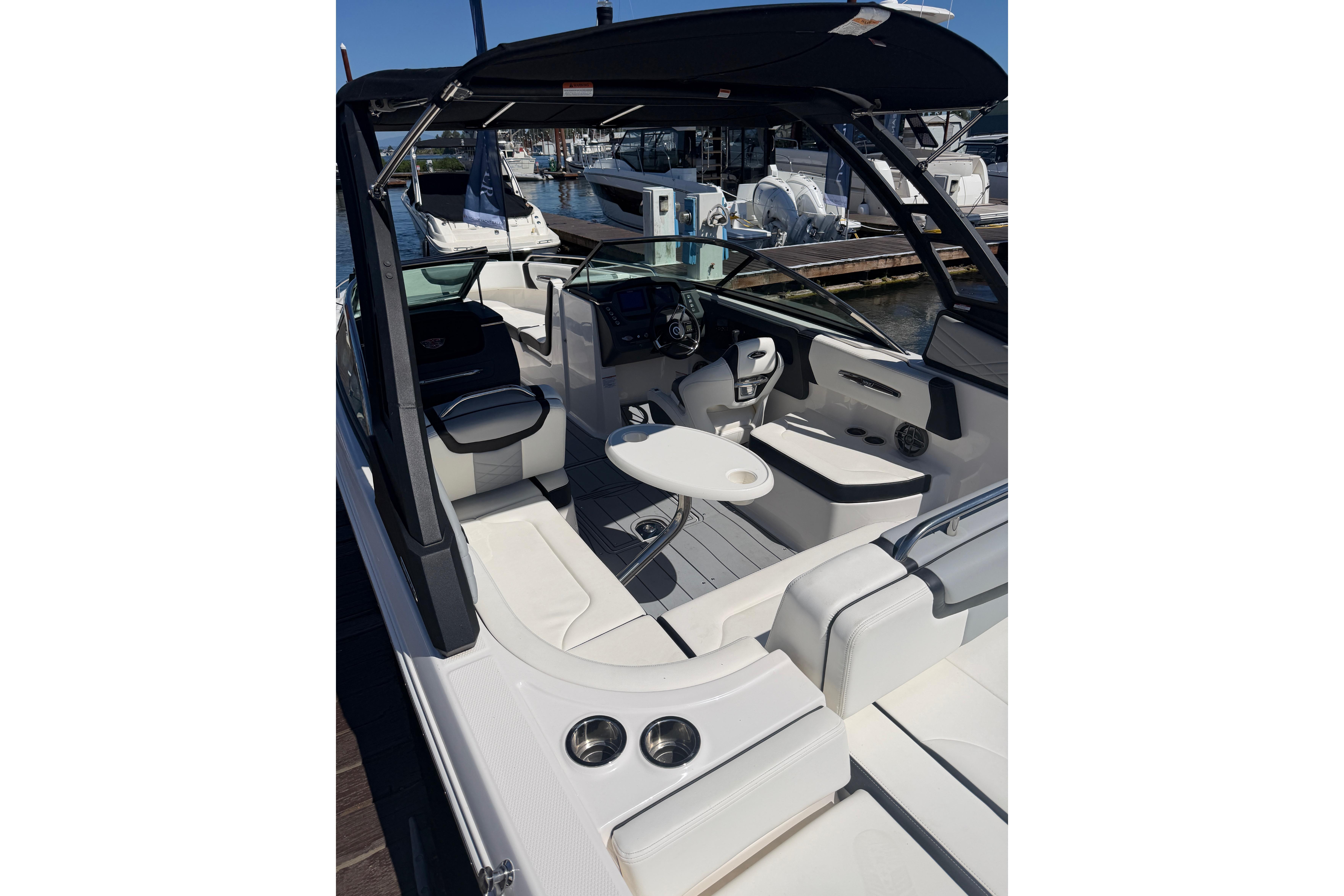 2023 Chaparral 247 SSX boat interior with seating and steering wheel, docked at marina.