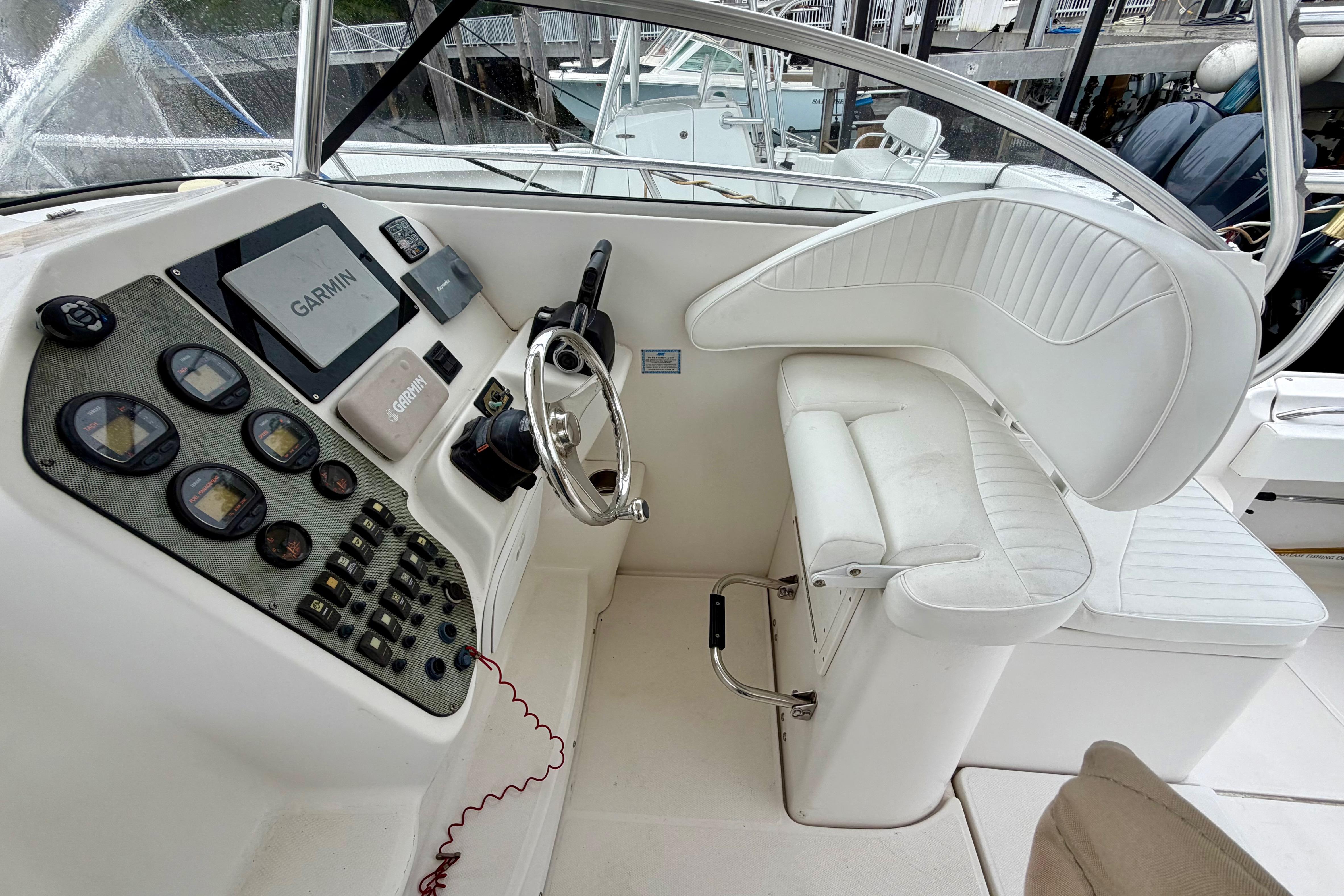 2006 Seaswirl Striper 2901 Walkaround O/B helm with Garmin navigation and white seating.