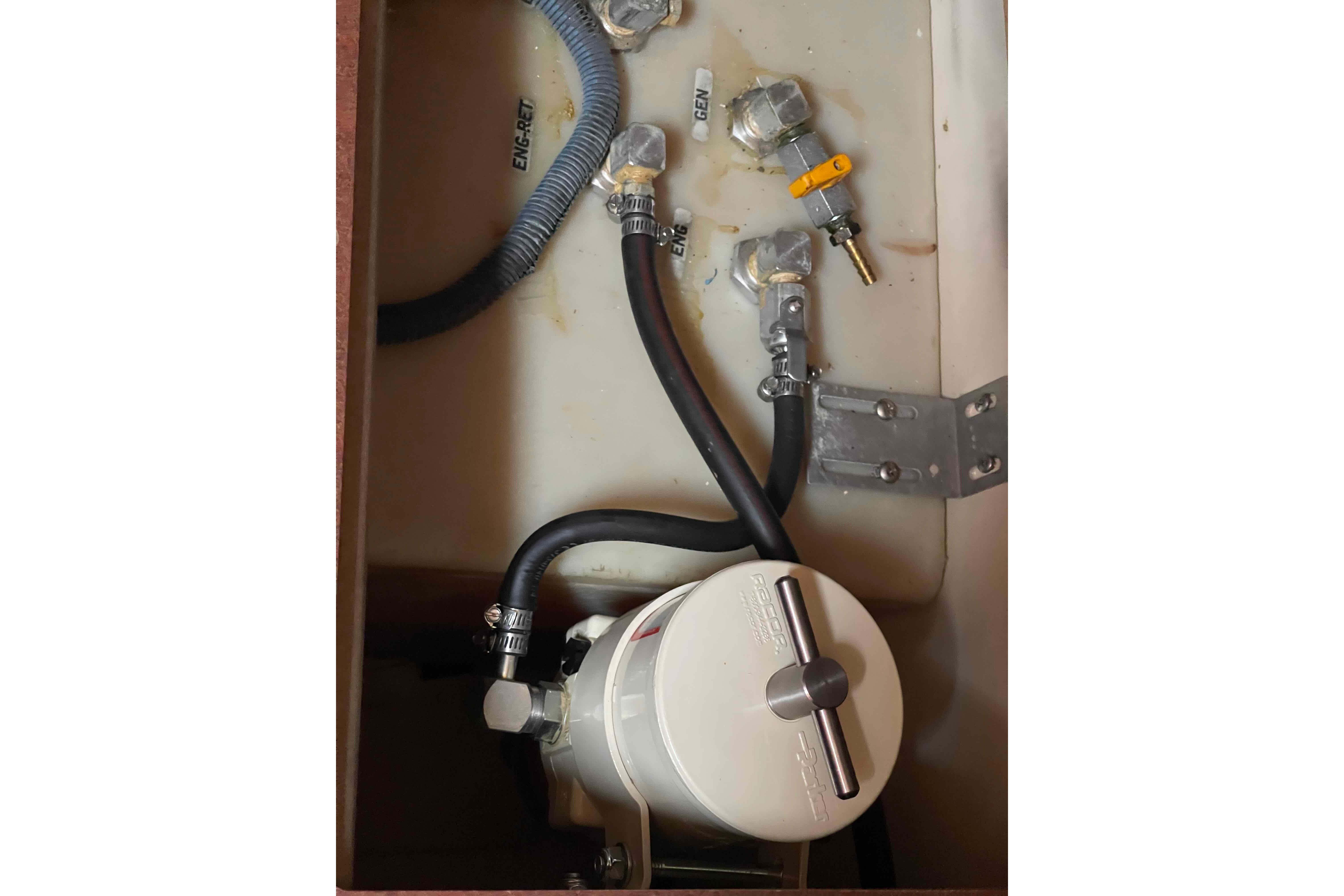 Engine compartment of a 2004 Hunter 36 sailboat, featuring hoses and a fuel filter system.