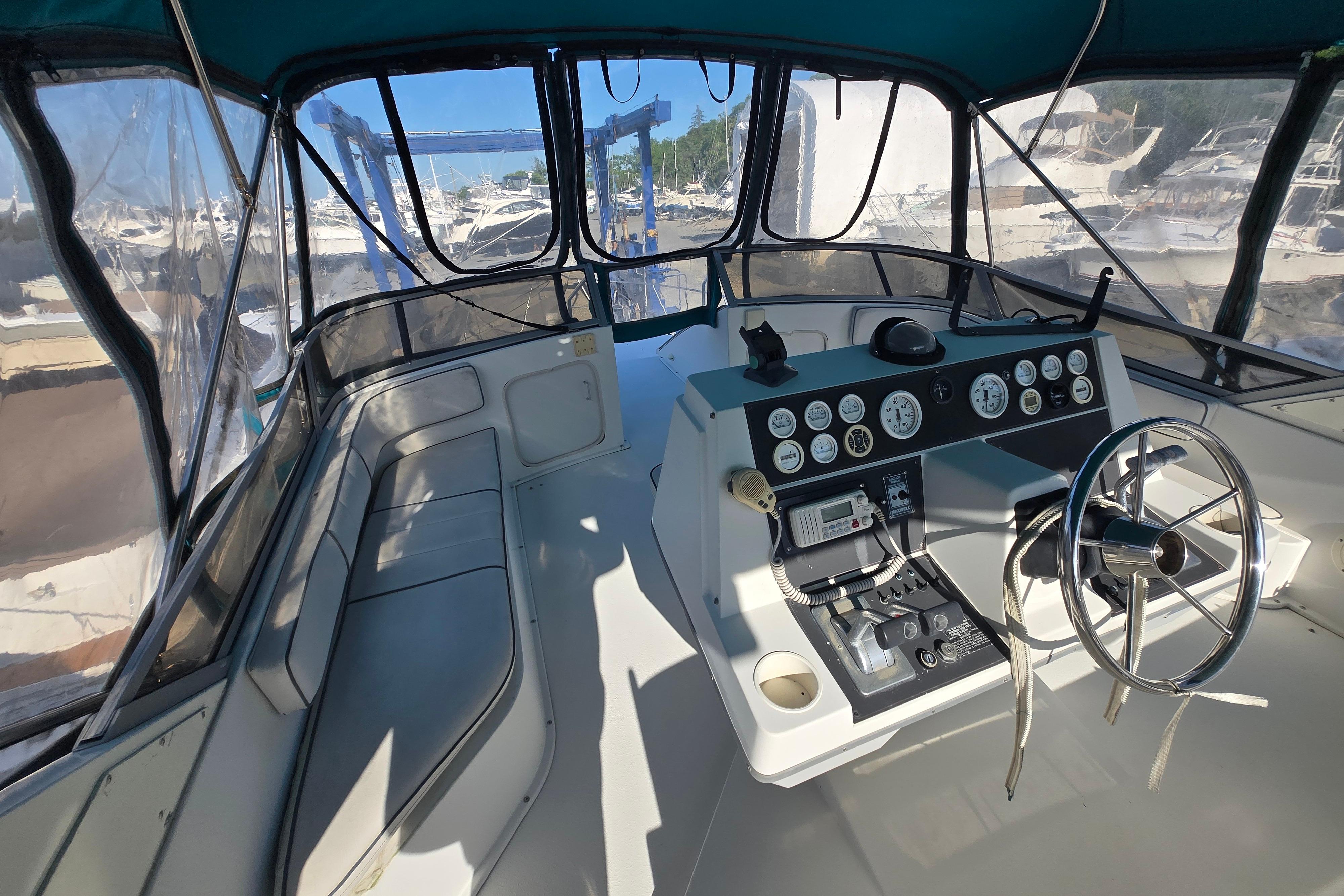 Interior view of 1994 Carver 380 Santego yacht cockpit with steering wheel and control panel.