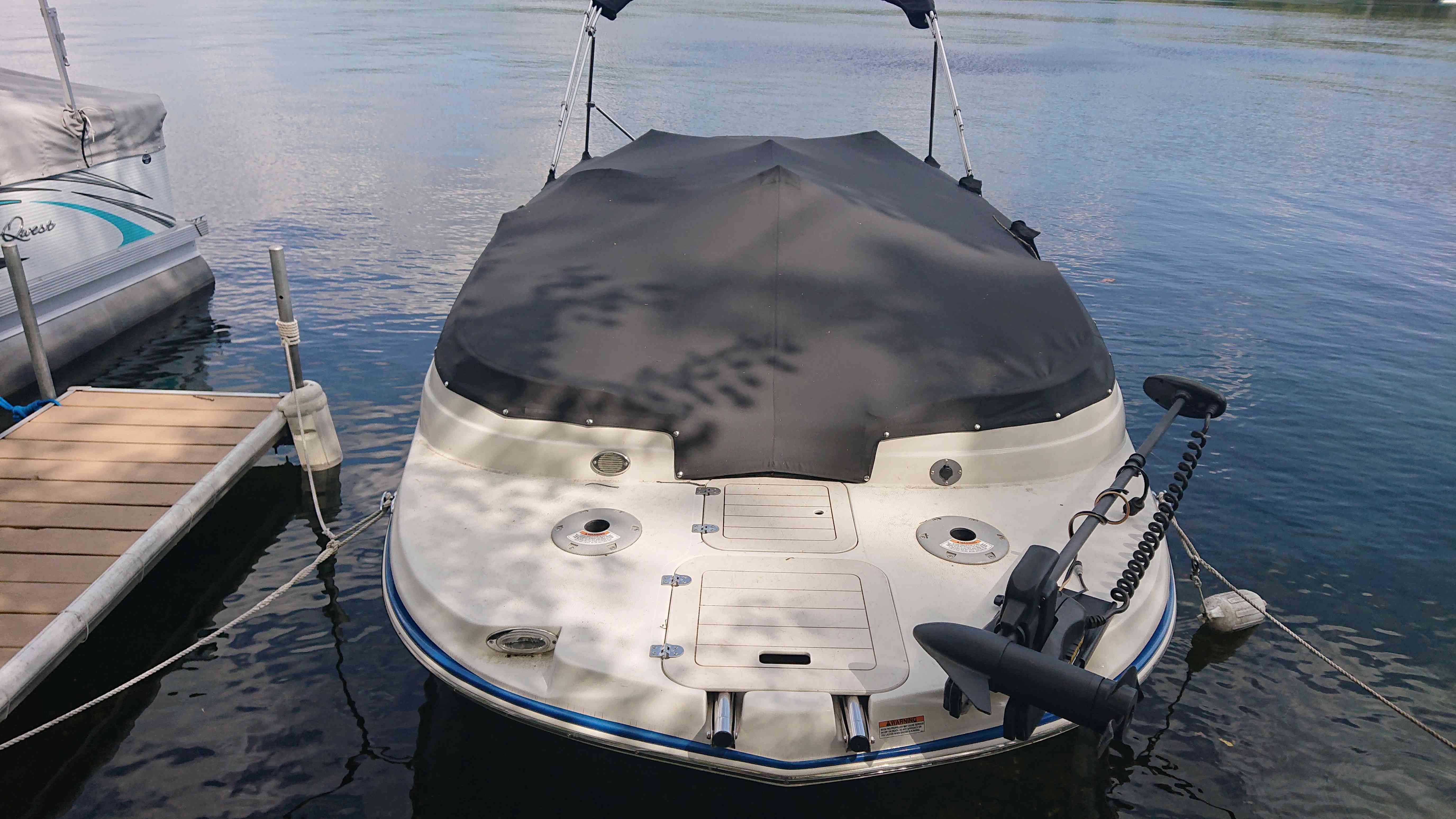 2015 Starcraft 2000 boat docked on calm water.