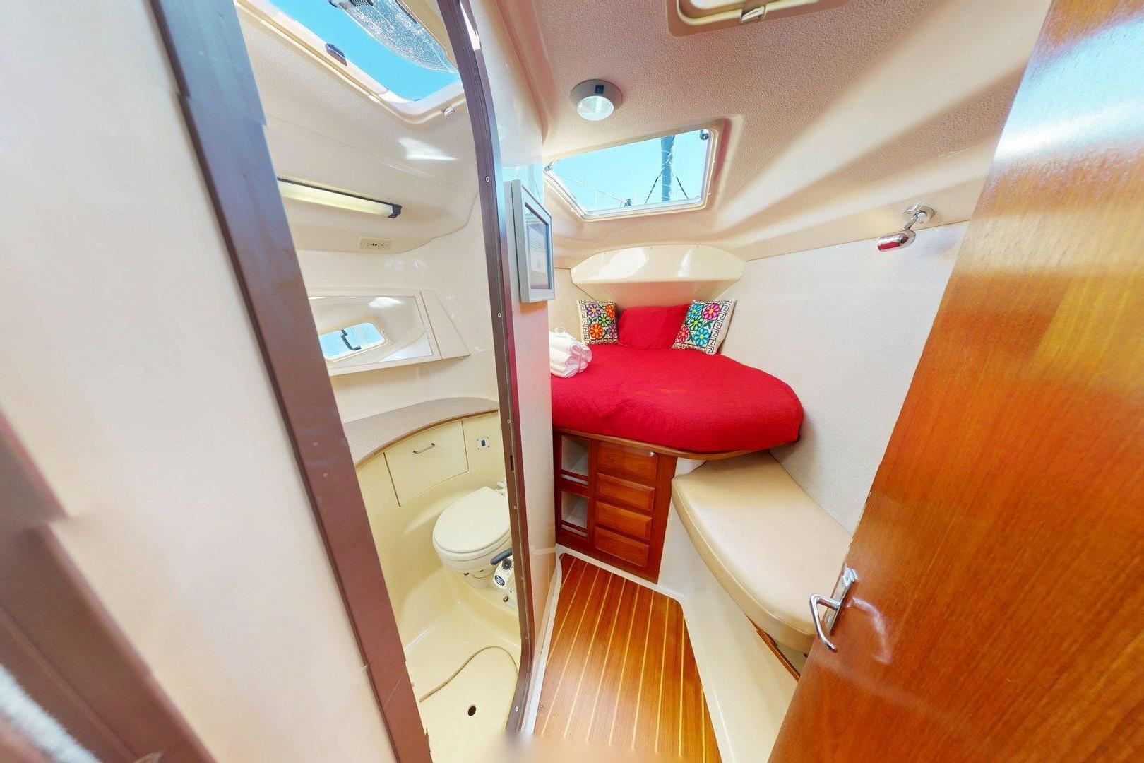 Interior of 1997 Hunter Legend 40.5 yacht with cozy cabin and vibrant bedding.