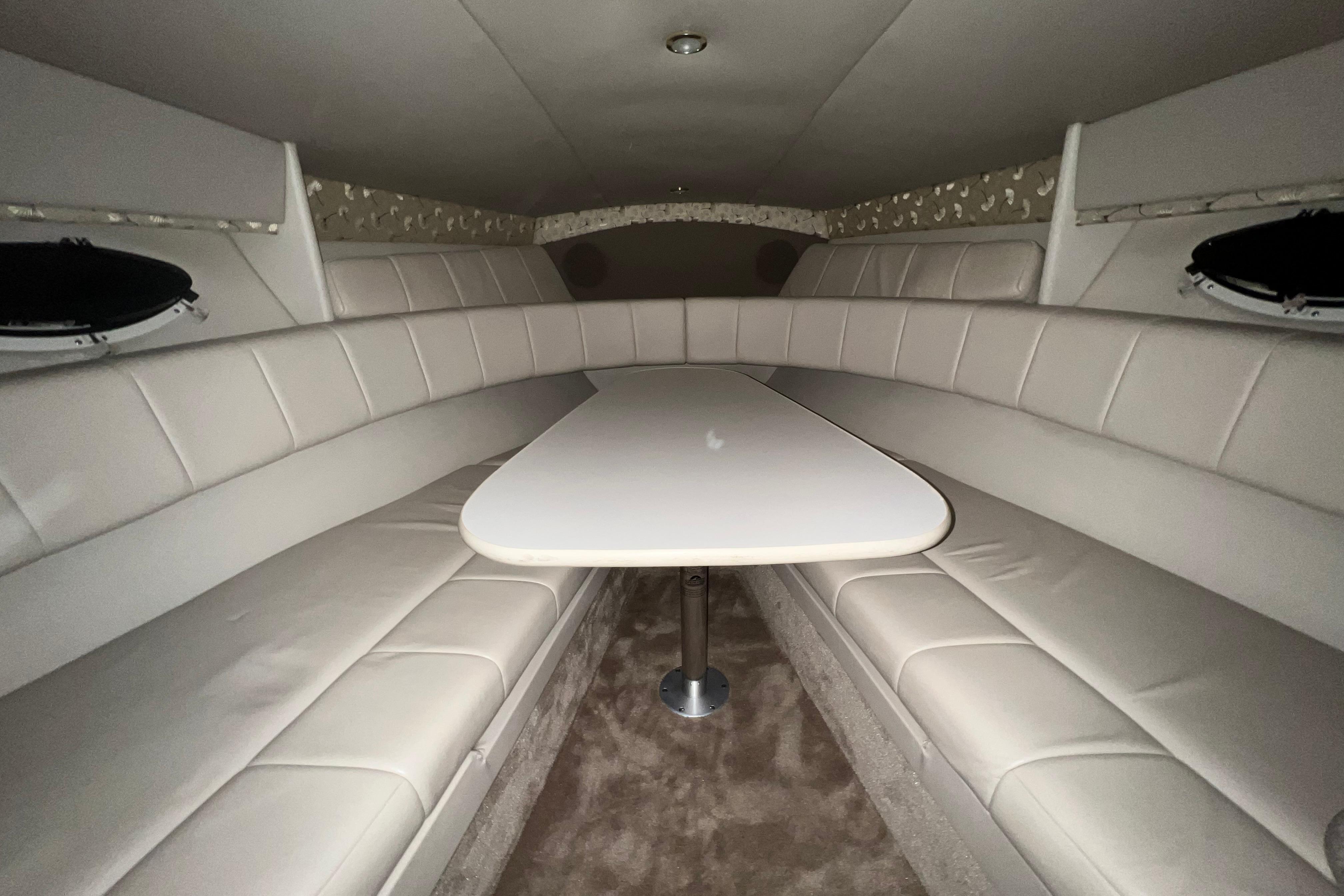 Interior of a 1999 Formula 330 Sun Sport boat with beige seating and table.