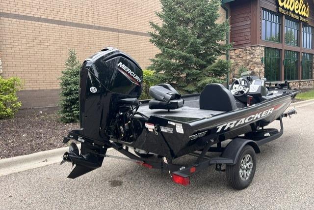 2026 Tracker Pro Team 175 boat with Mercury engine parked outside Cabela's store.