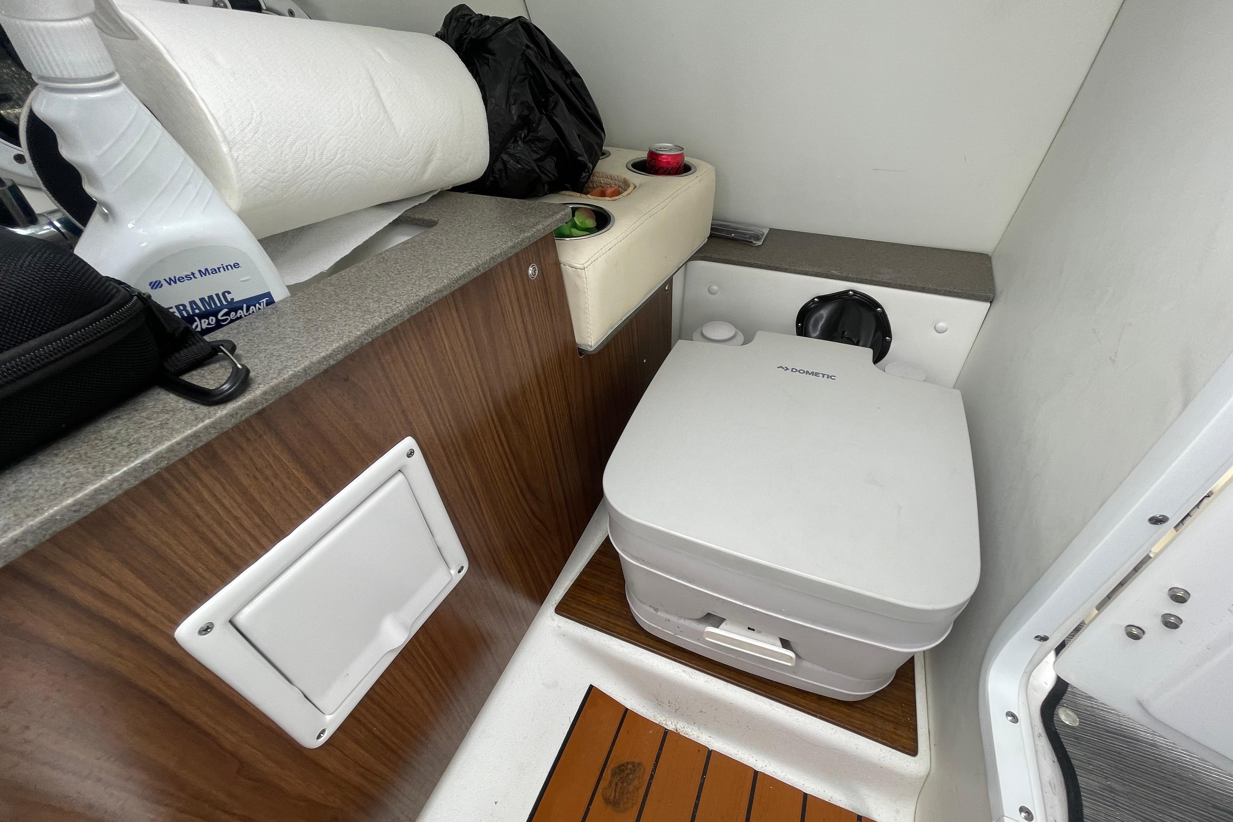 2022 Four Winns HD8 OB boat interior with compact marine toilet and storage area.