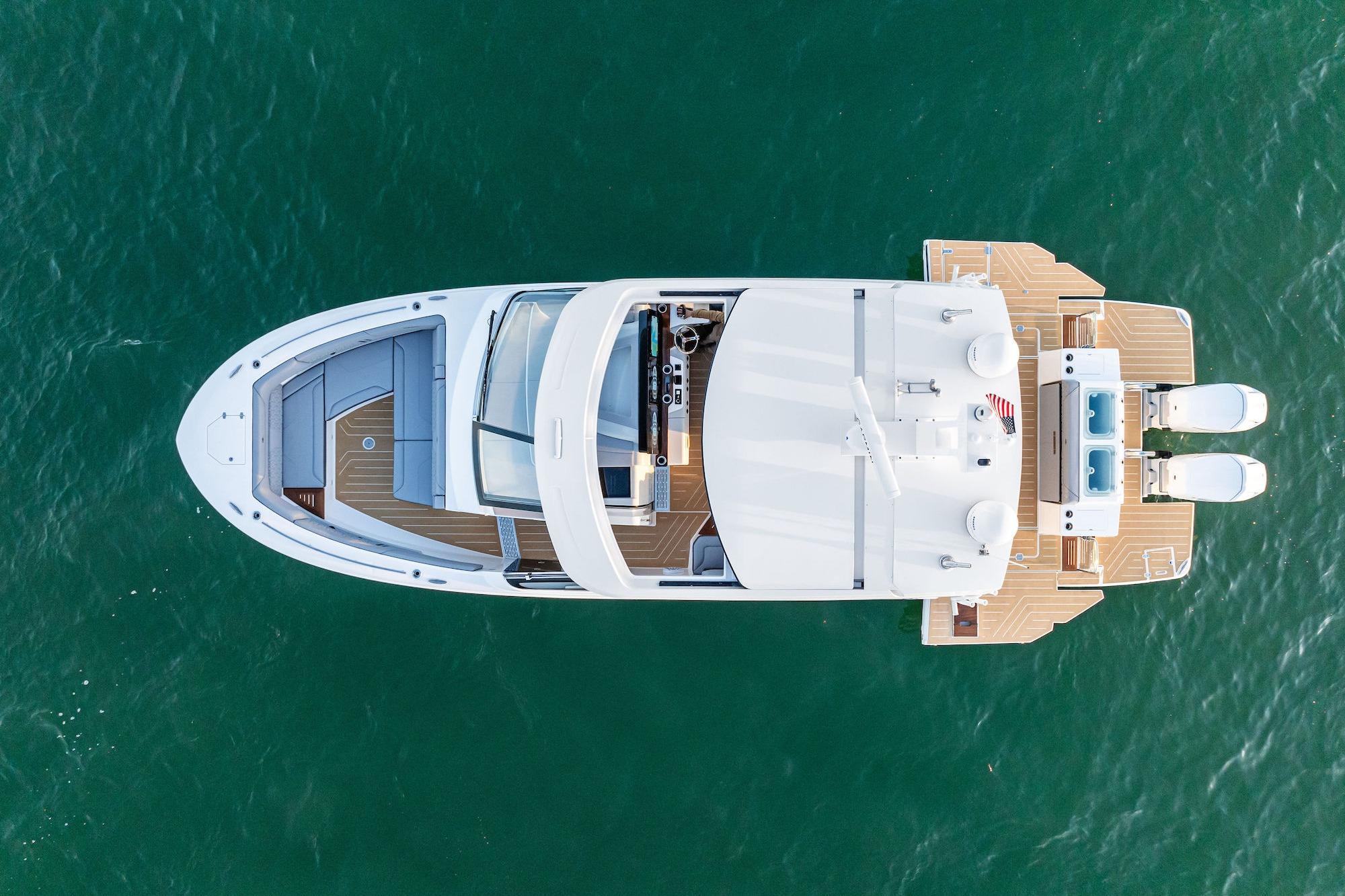 Aerial view of 2026 Regal LX43 yacht on clear blue water.