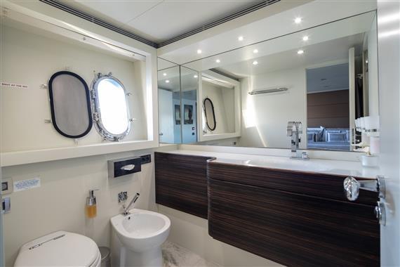 Luxurious bathroom on 2009 Canados 110' yacht with modern fixtures and porthole window.