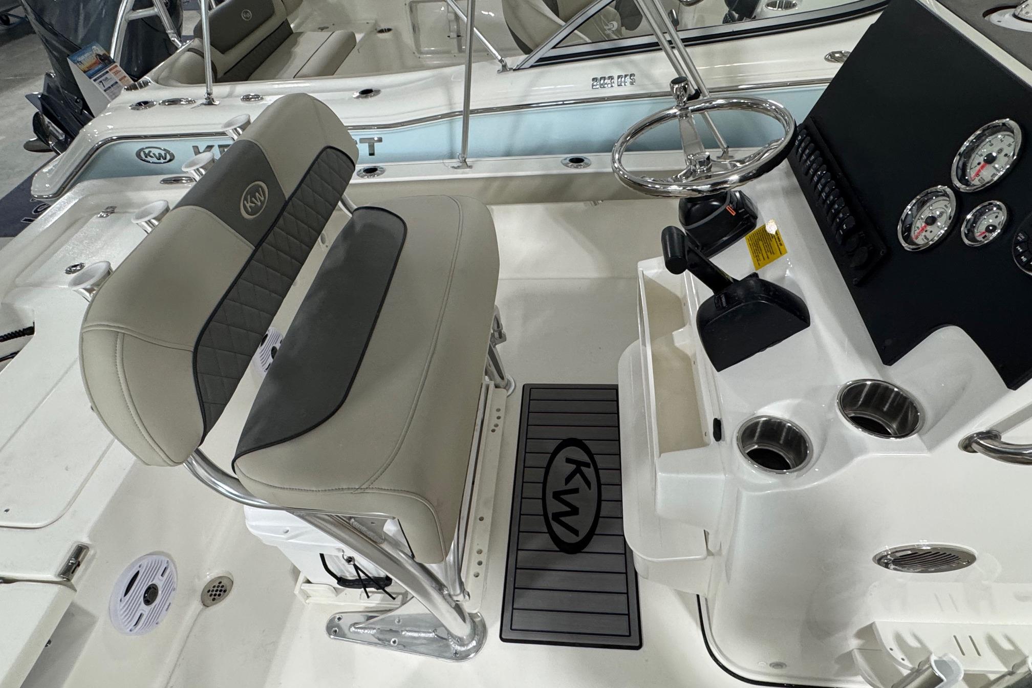 2026 Key West 210 Bay Reef boat interior with steering console and cushioned seating.