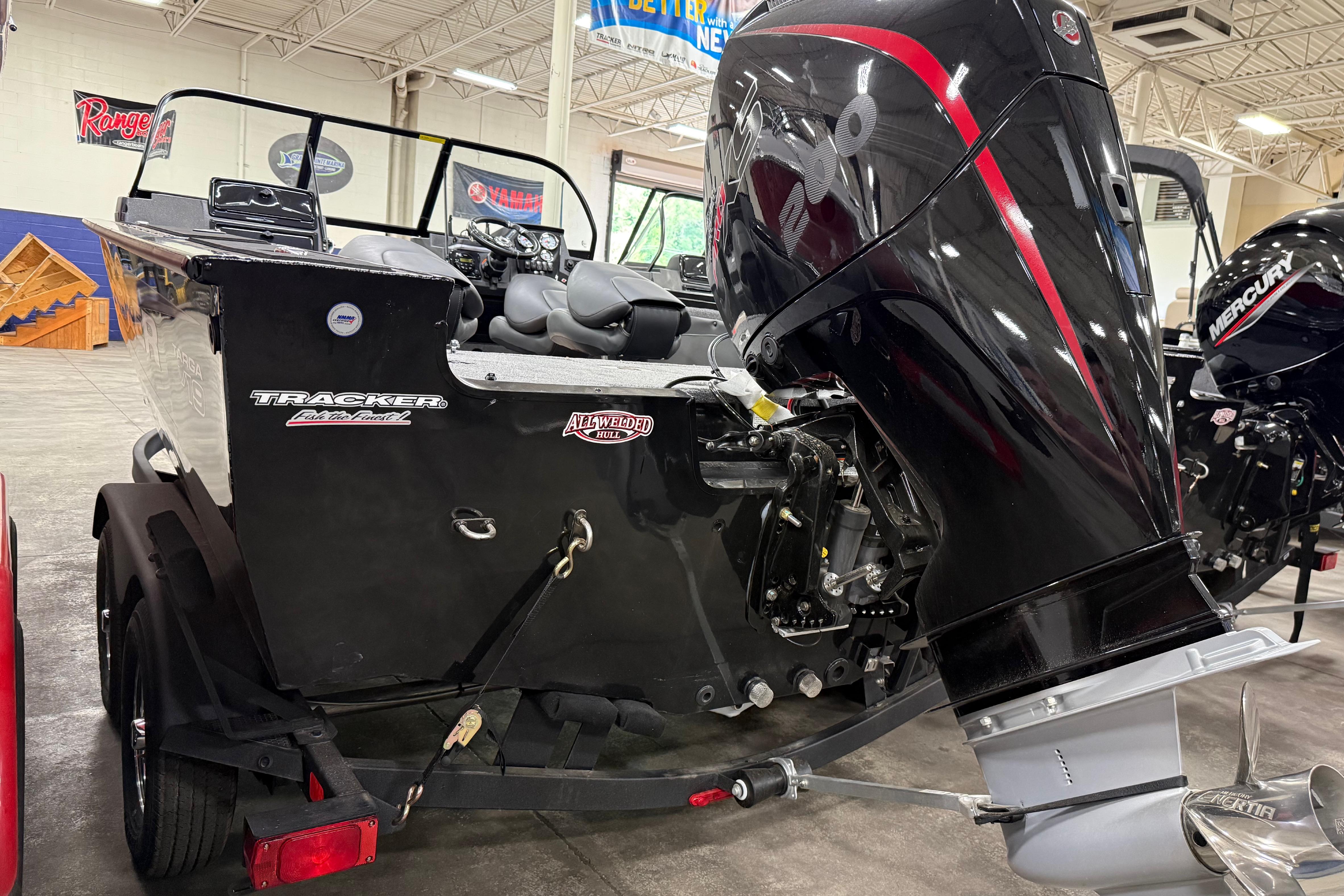 2026 Tracker Targa V-19 WT boat with powerful outboard motor in showroom.