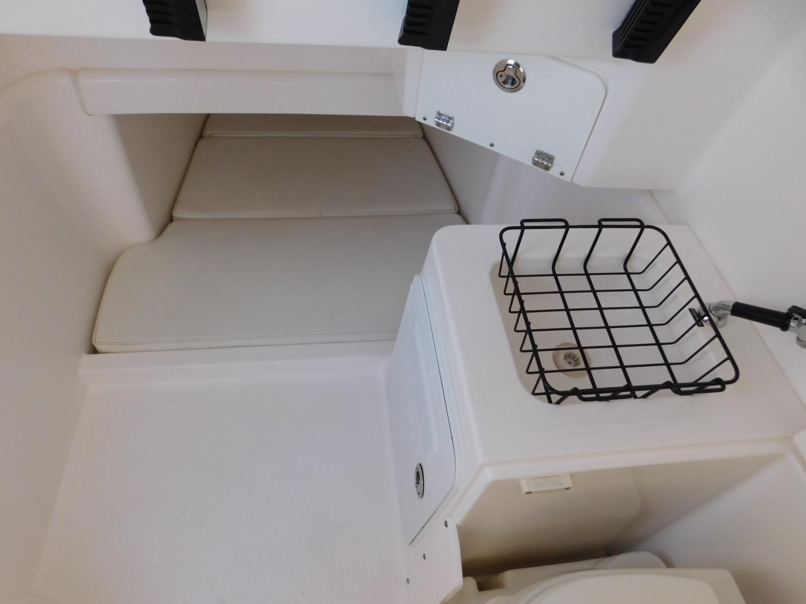Interior cabin of 2016 Everglades 355 Center Console boat with storage basket.