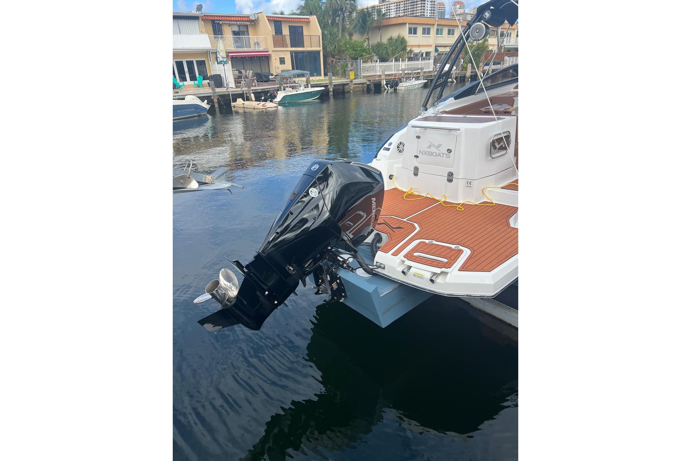2024 NX Boats NX270 with outboard motor docked in a canal.
