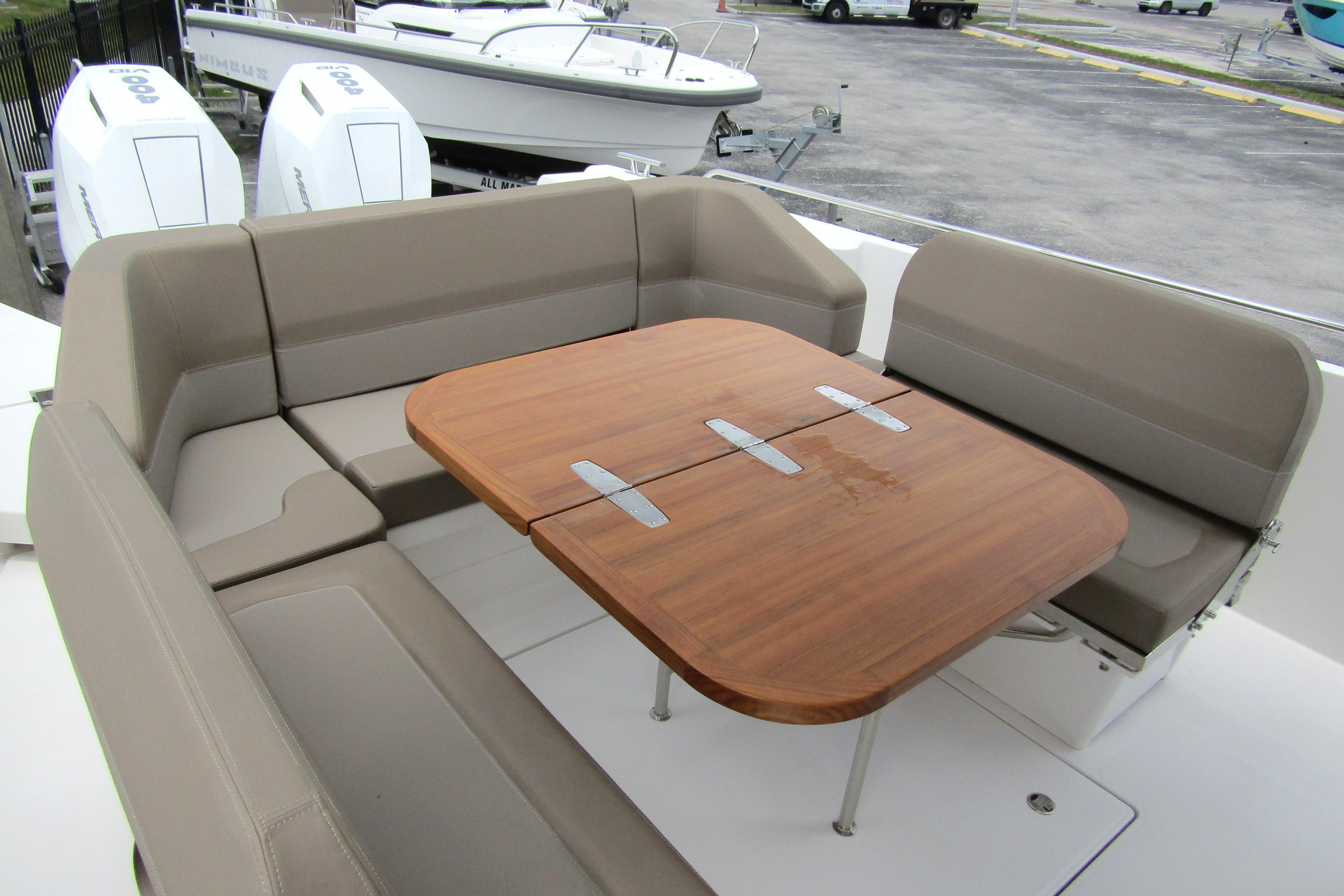 Luxurious seating area on 2025 Nimbus Tender 11 boat with wooden table.
