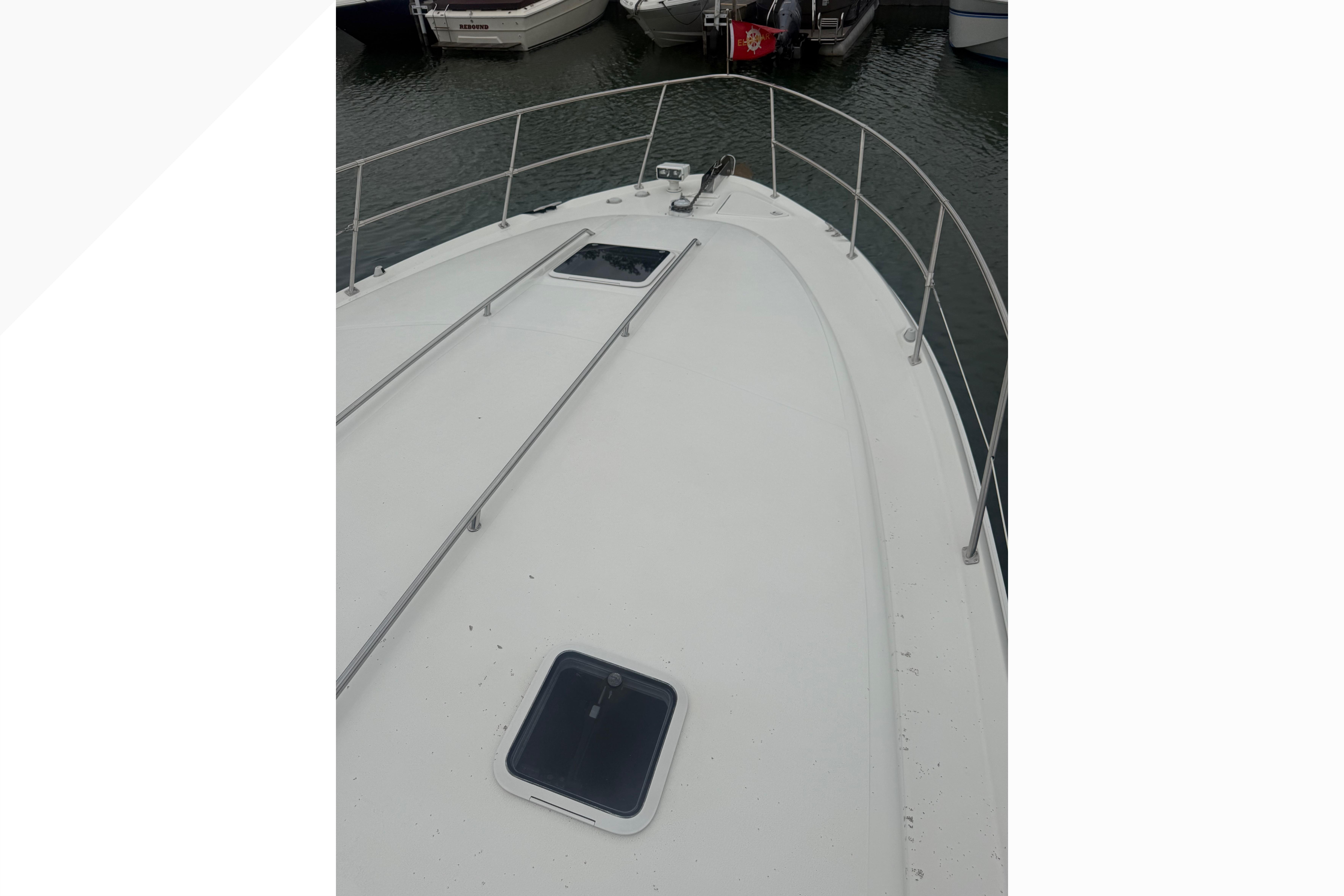 1998 Sea Ray Sundancer 400 yacht deck with railing and hatches, docked in marina.