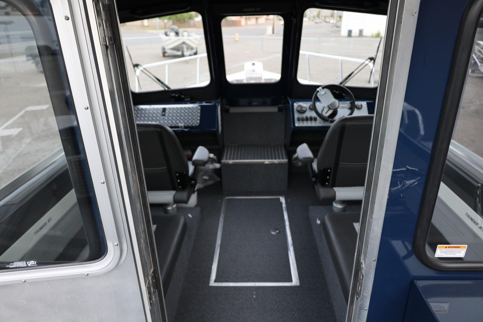 Interior view of 2026 Thunder Jet 24 Alexis Pro boat, showcasing seating and steering area.