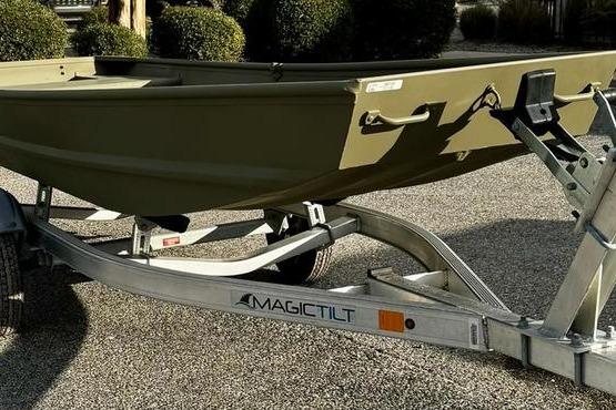 2026 Tracker Grizzly 14 Jon boat on Magic Tilt trailer, parked on gravel.