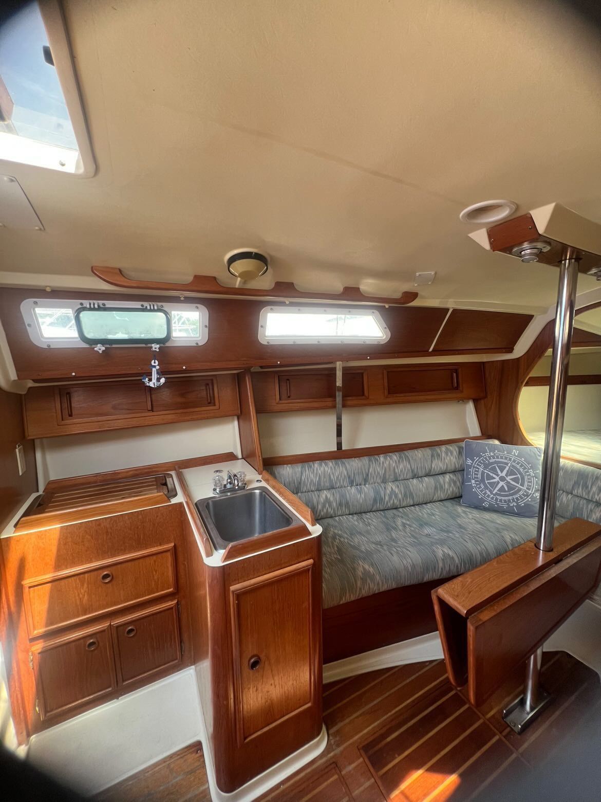 Interior of a 1988 Pearson 28 sailboat with wooden cabinetry and a small sink.