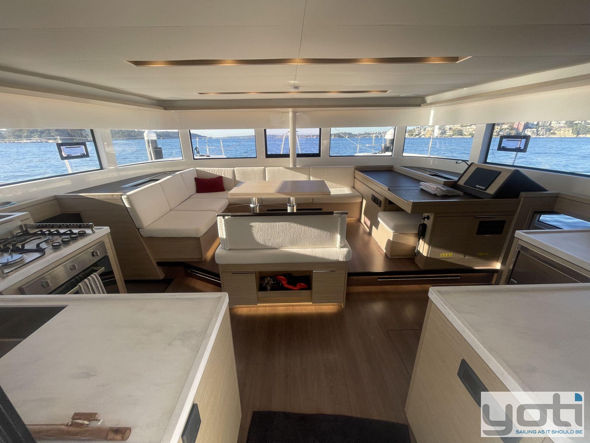 Luxurious interior of 2023 Lagoon 51 yacht with modern kitchen and seating area.
