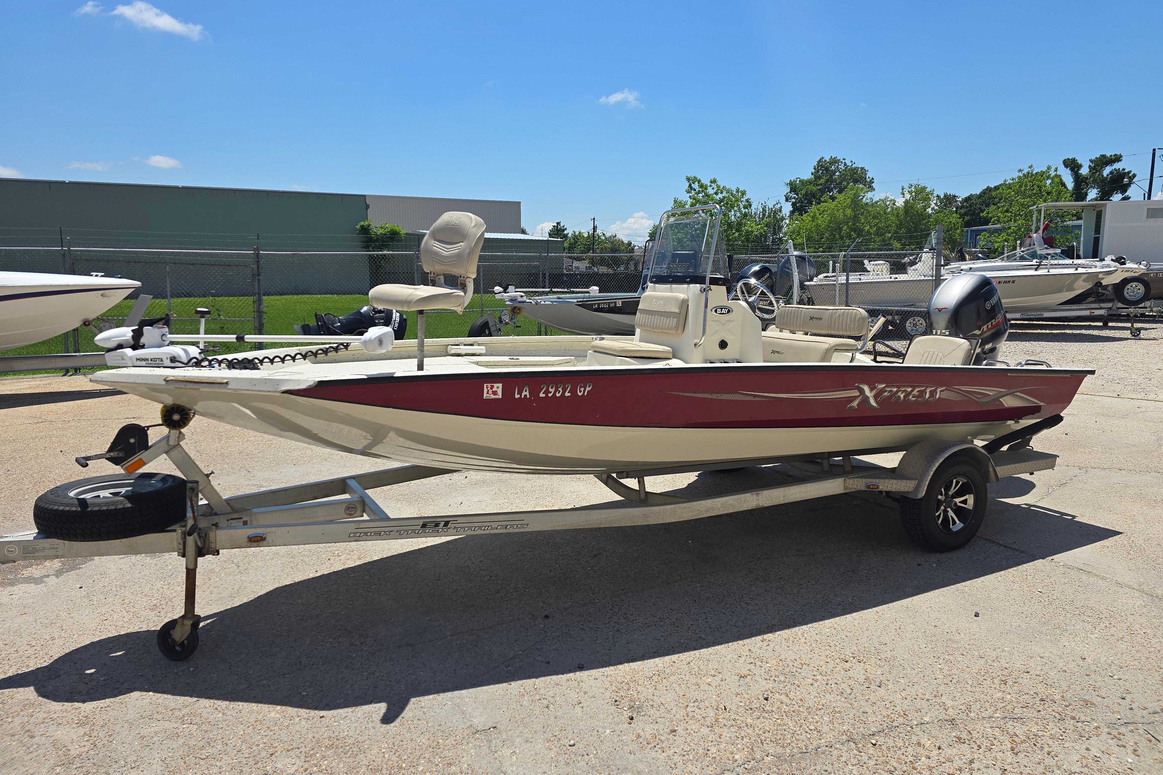 2016 Xpress H20B Bay boat on trailer, parked outdoors under clear sky.