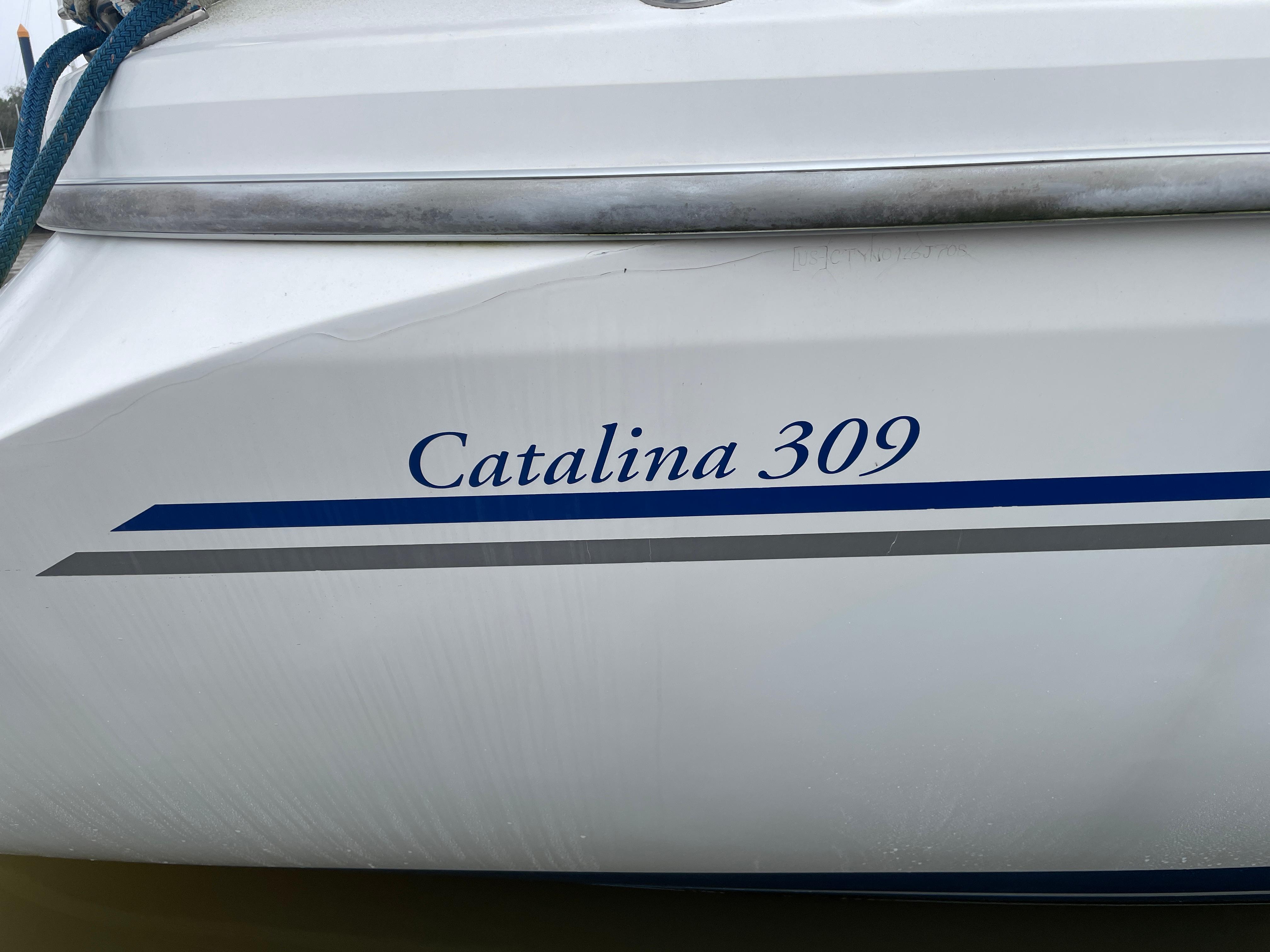 2008 Catalina 309 sailboat hull with blue and gray stripes.