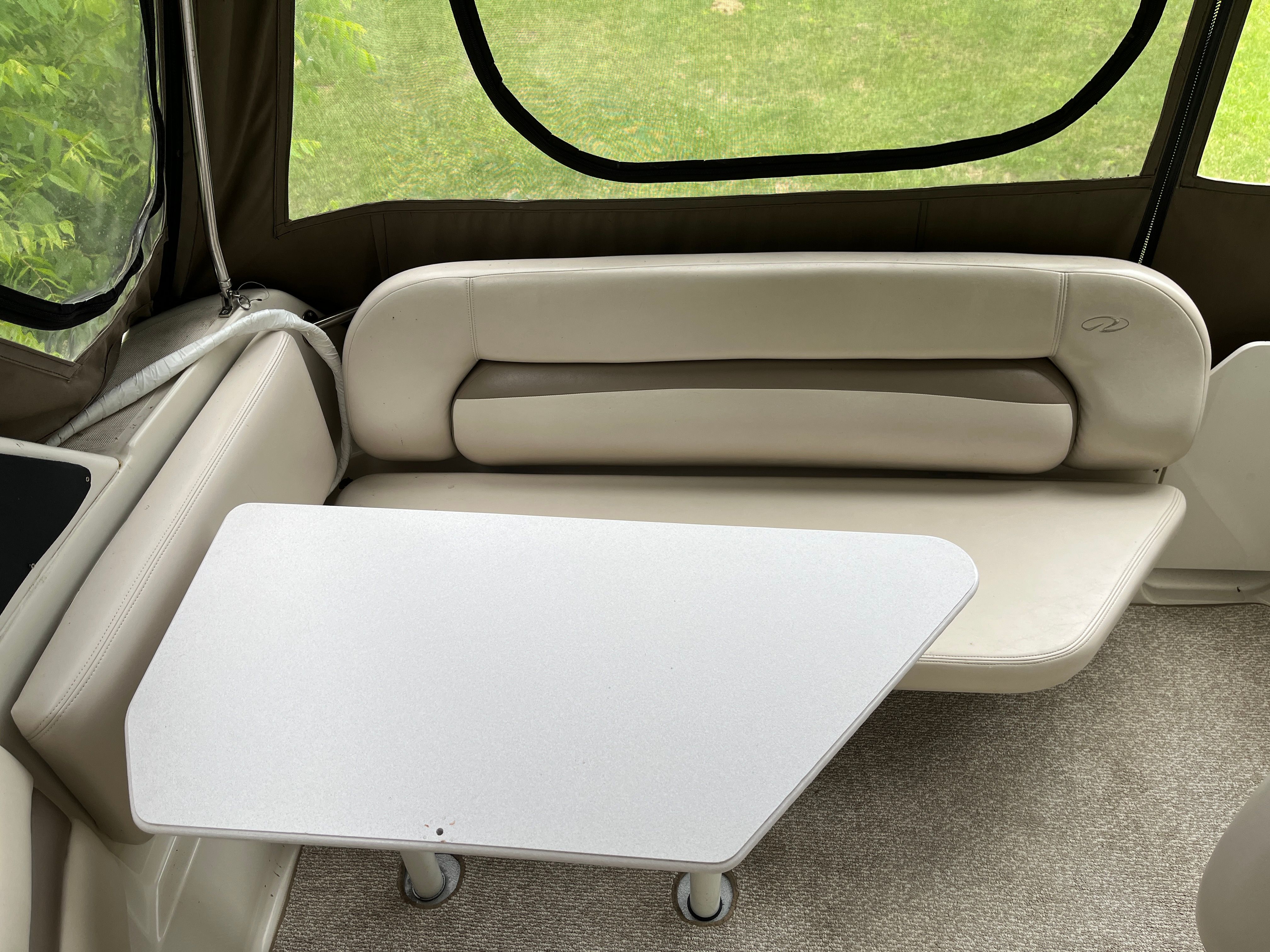 Interior of a 1998 Regal Commodore 2760 with a white table and beige seating.