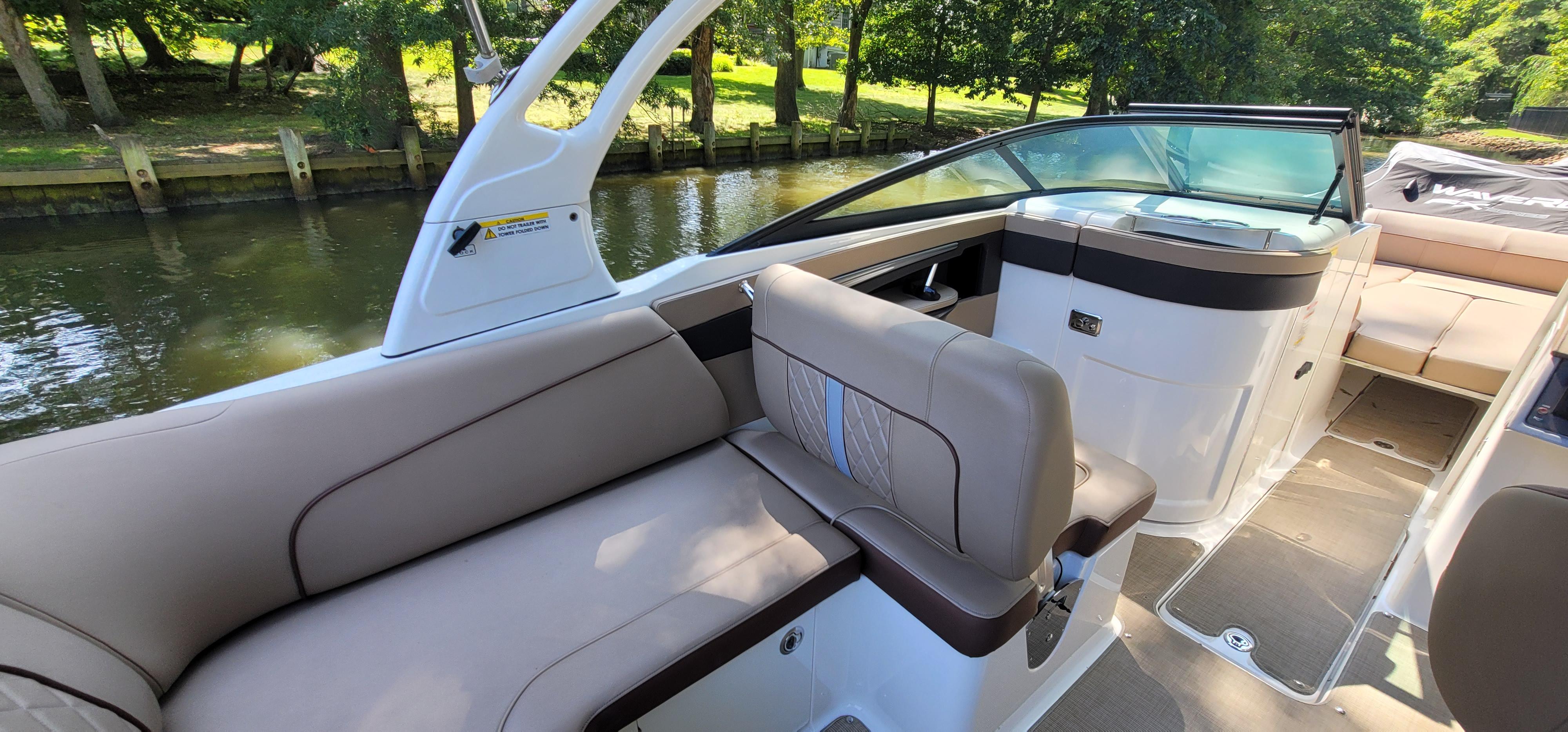 2017 Sea Ray SDX 240 Outboard boat interior with beige seating and scenic river backdrop.