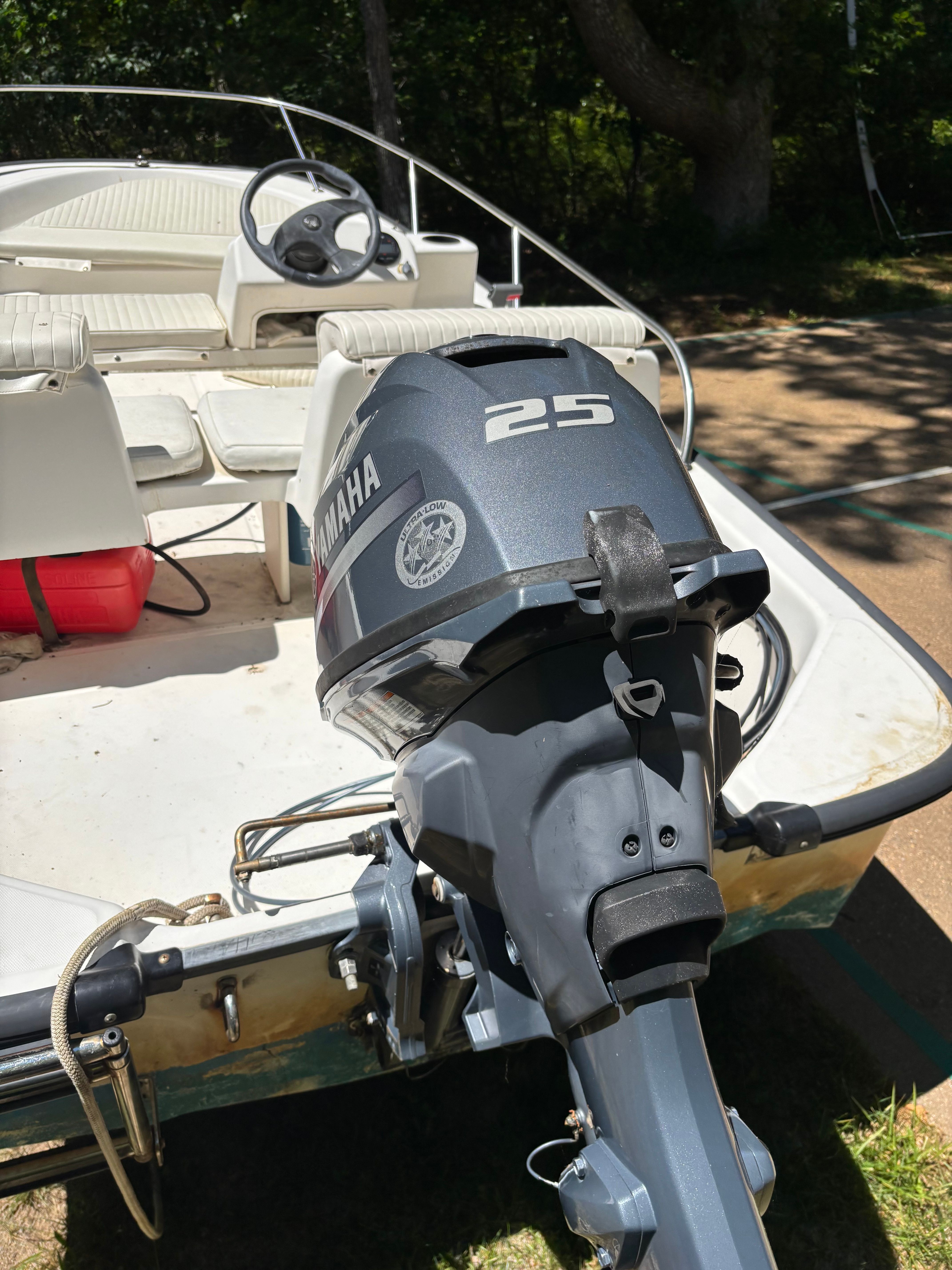 A Boston Whaler 130 Sport with a Yamaha 25 HP motor, on a trailer outdoors.