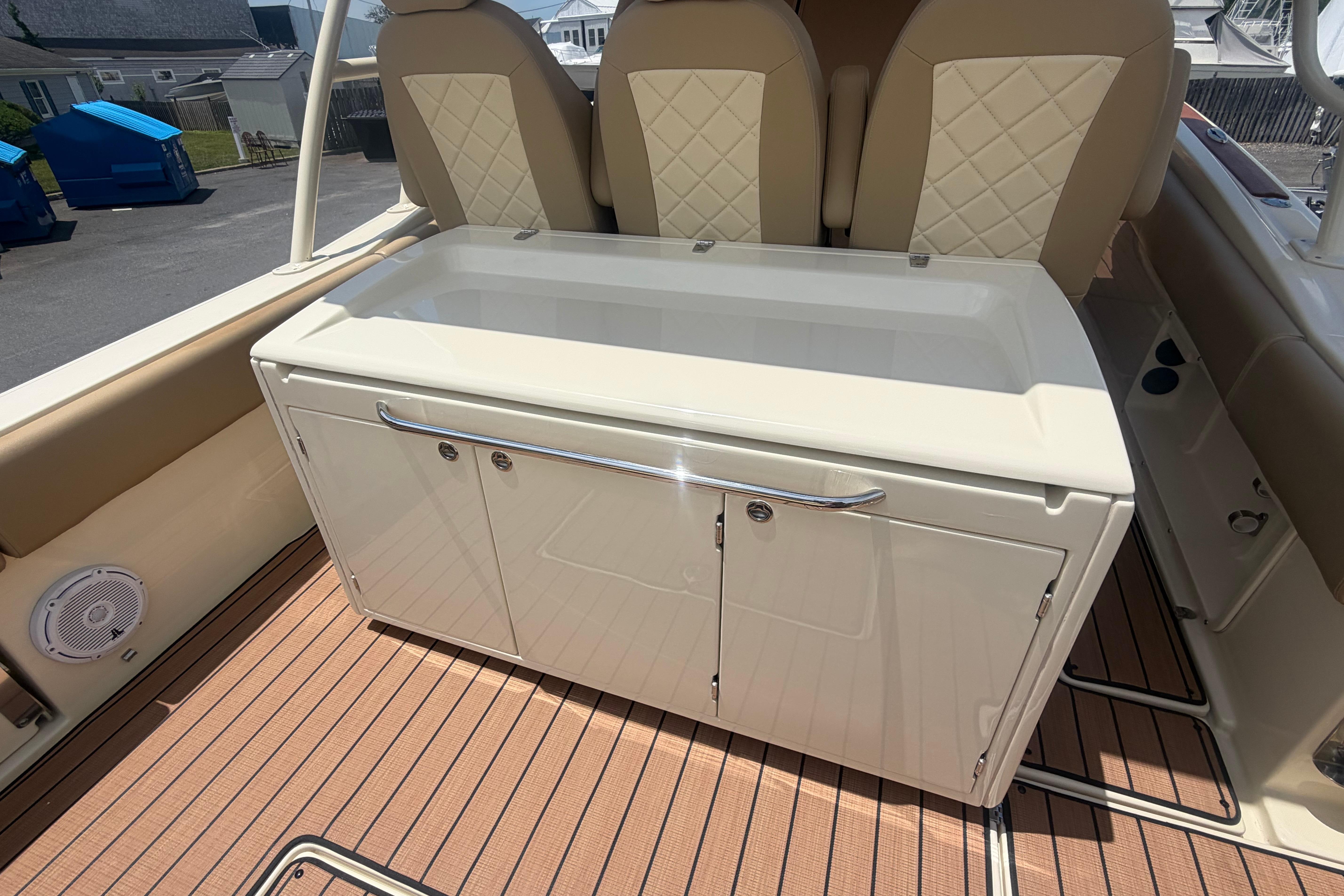 2017 Chris-Craft Catalina 34 interior with beige seating and storage cabinet.