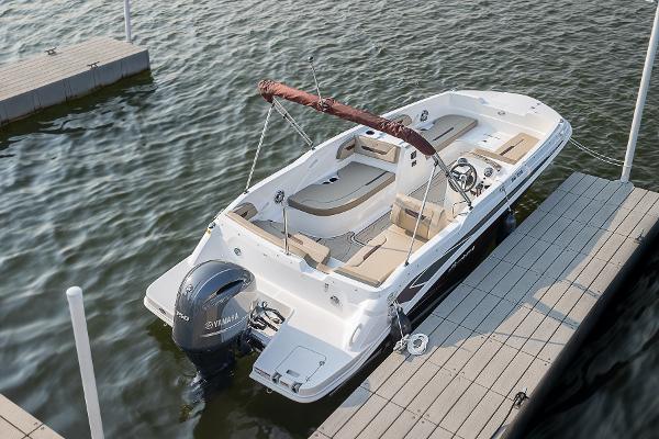 2025 Hurricane SunDeck Sport 205 OB boat docked on calm water.