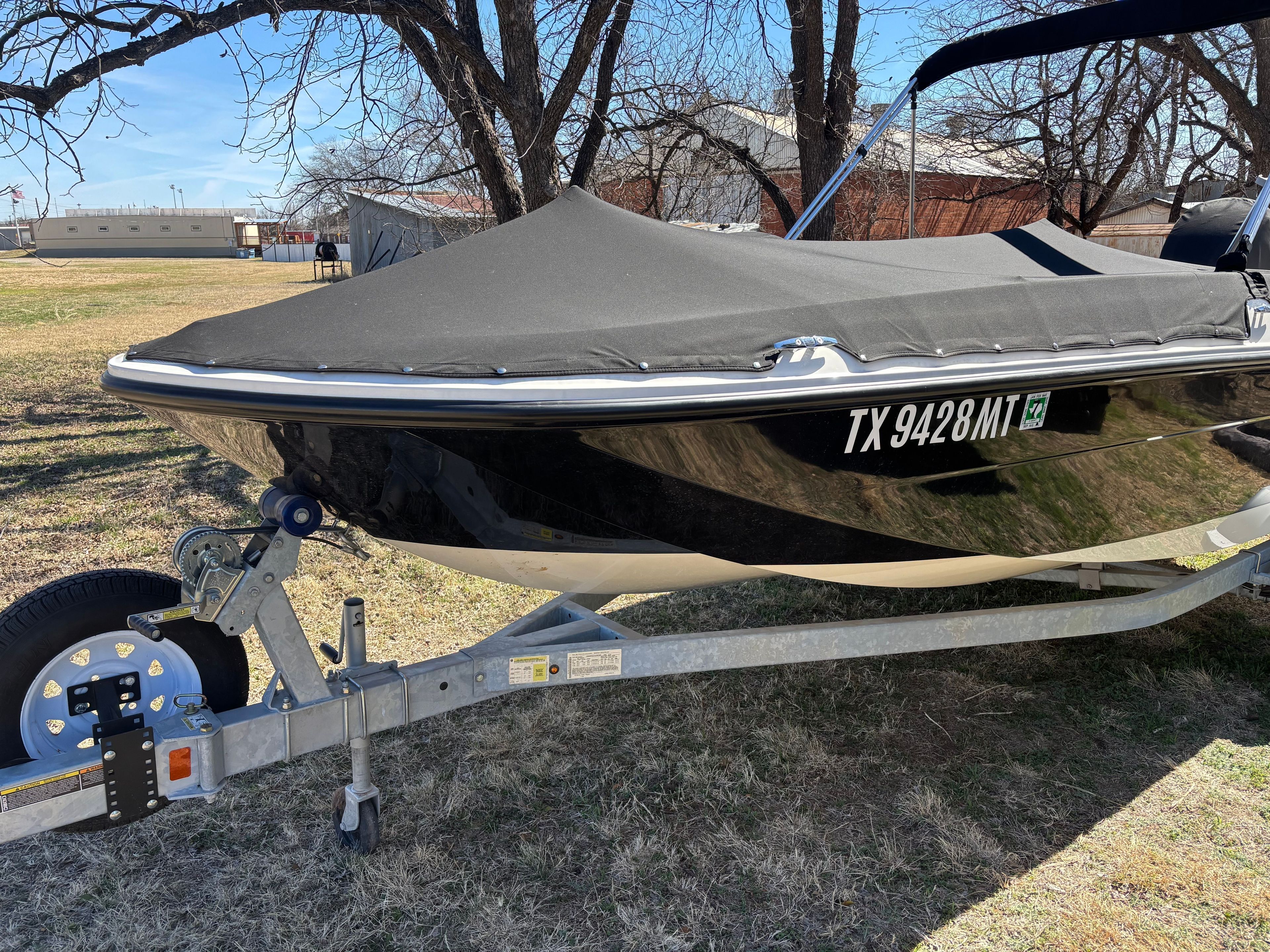 2025 Bayliner Element E18 boat on trailer, covered, parked outdoors.