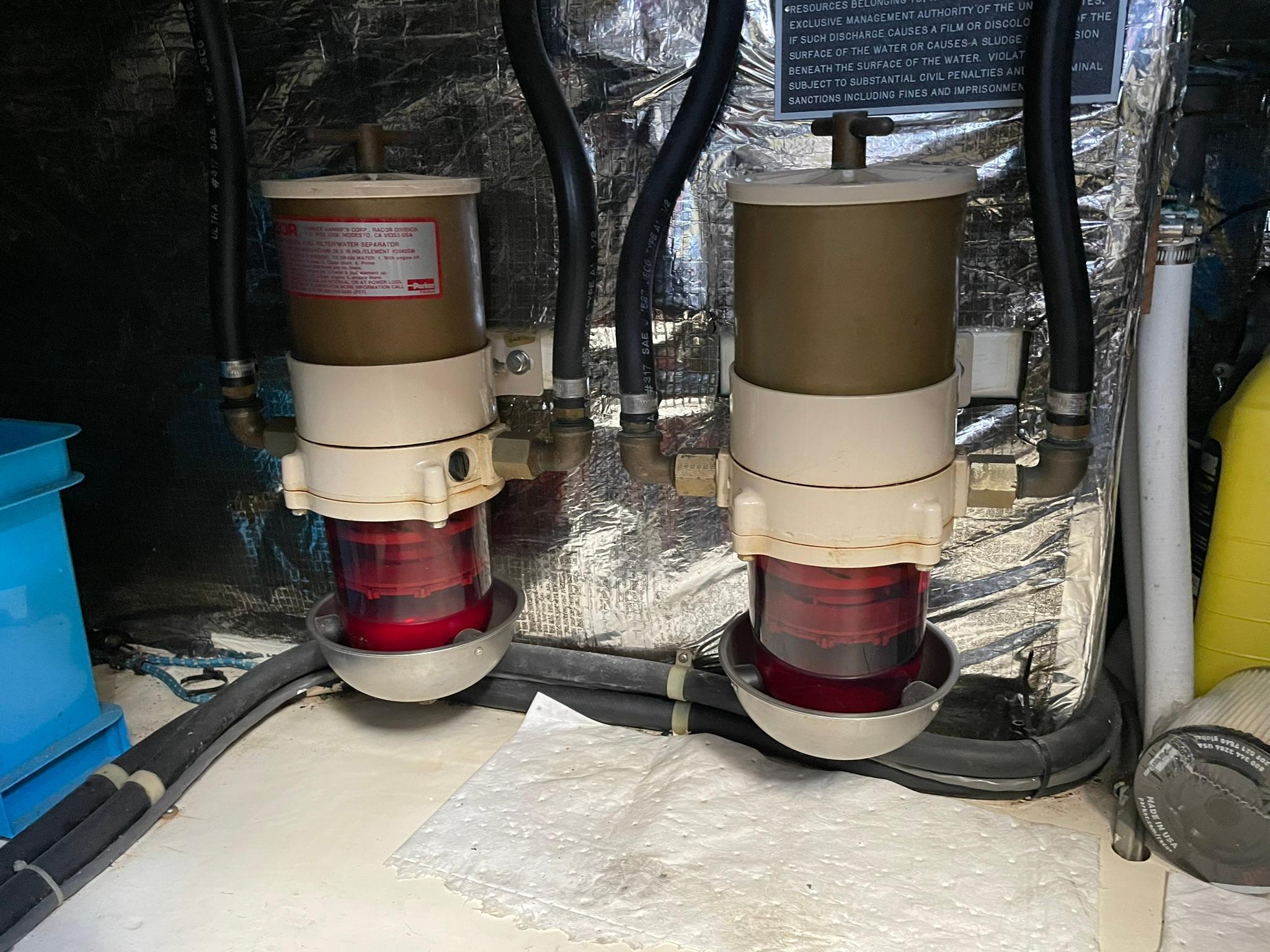 Engine room of 1994 Queenship Motor Yacht showing dual fuel filters and hoses.