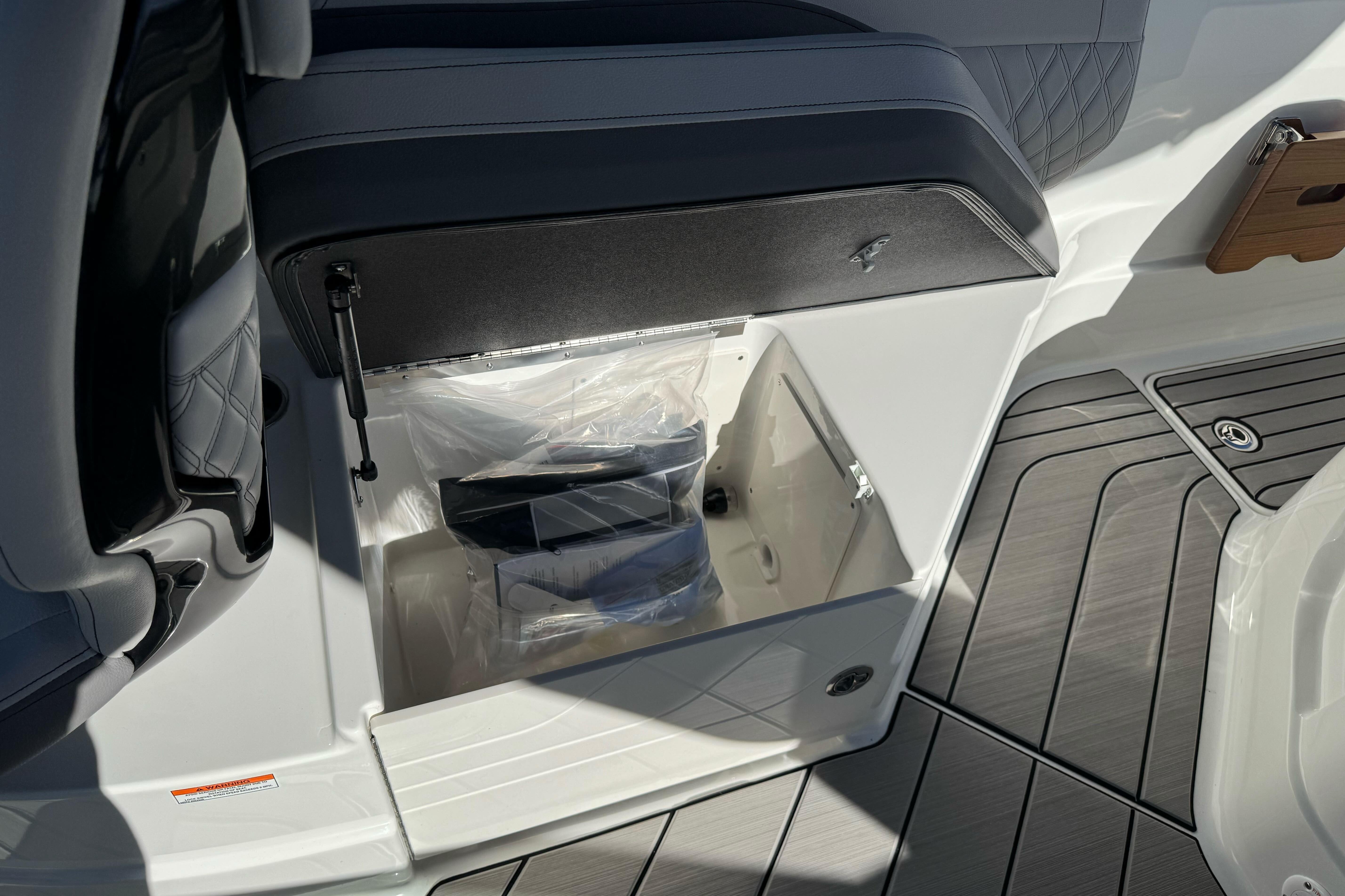 2026 Sea Ray SLX 260 boat storage compartment with open lid, showcasing interior space.