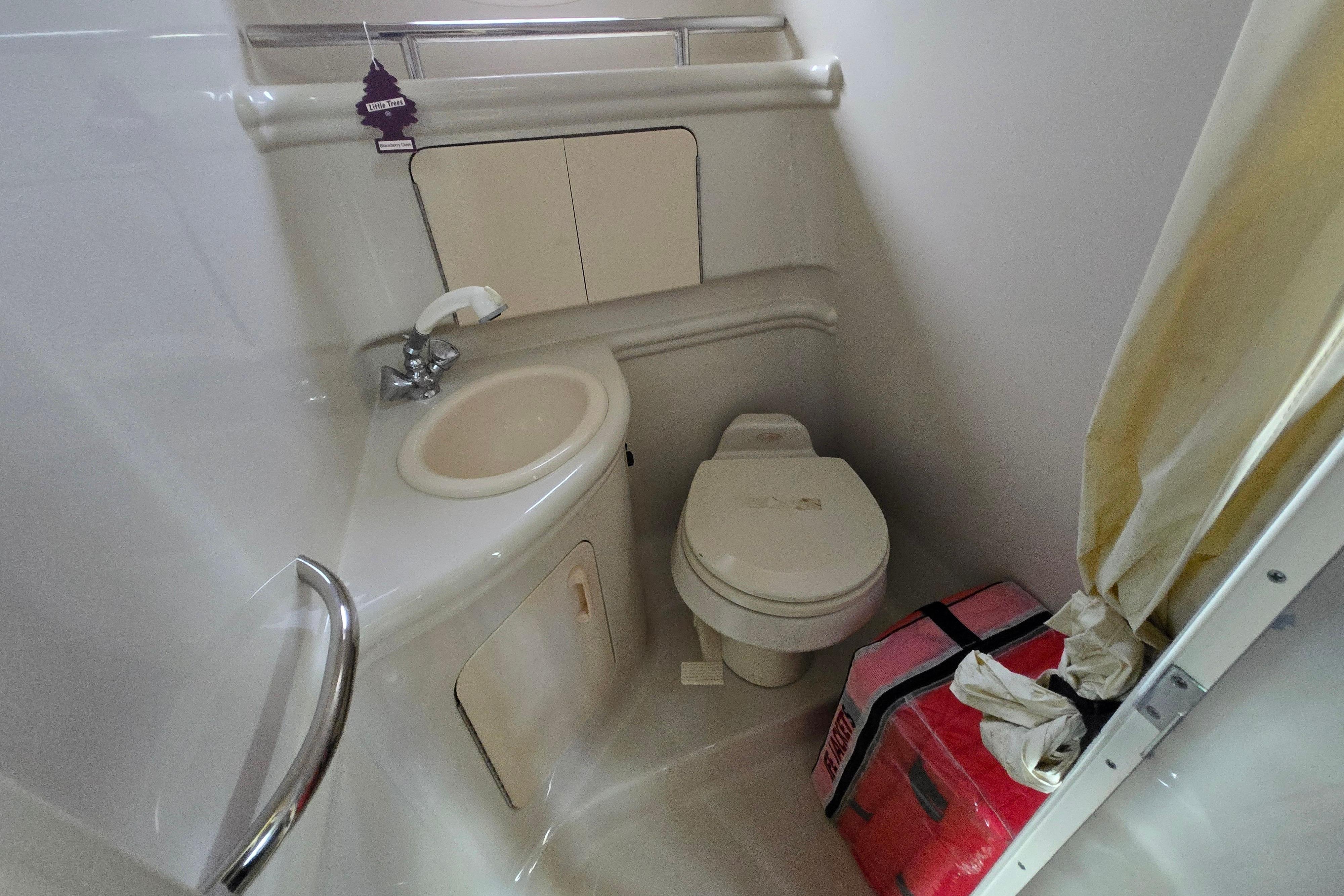 Compact bathroom in 2006 Sea Ray 280 Sundancer boat with sink and toilet.
