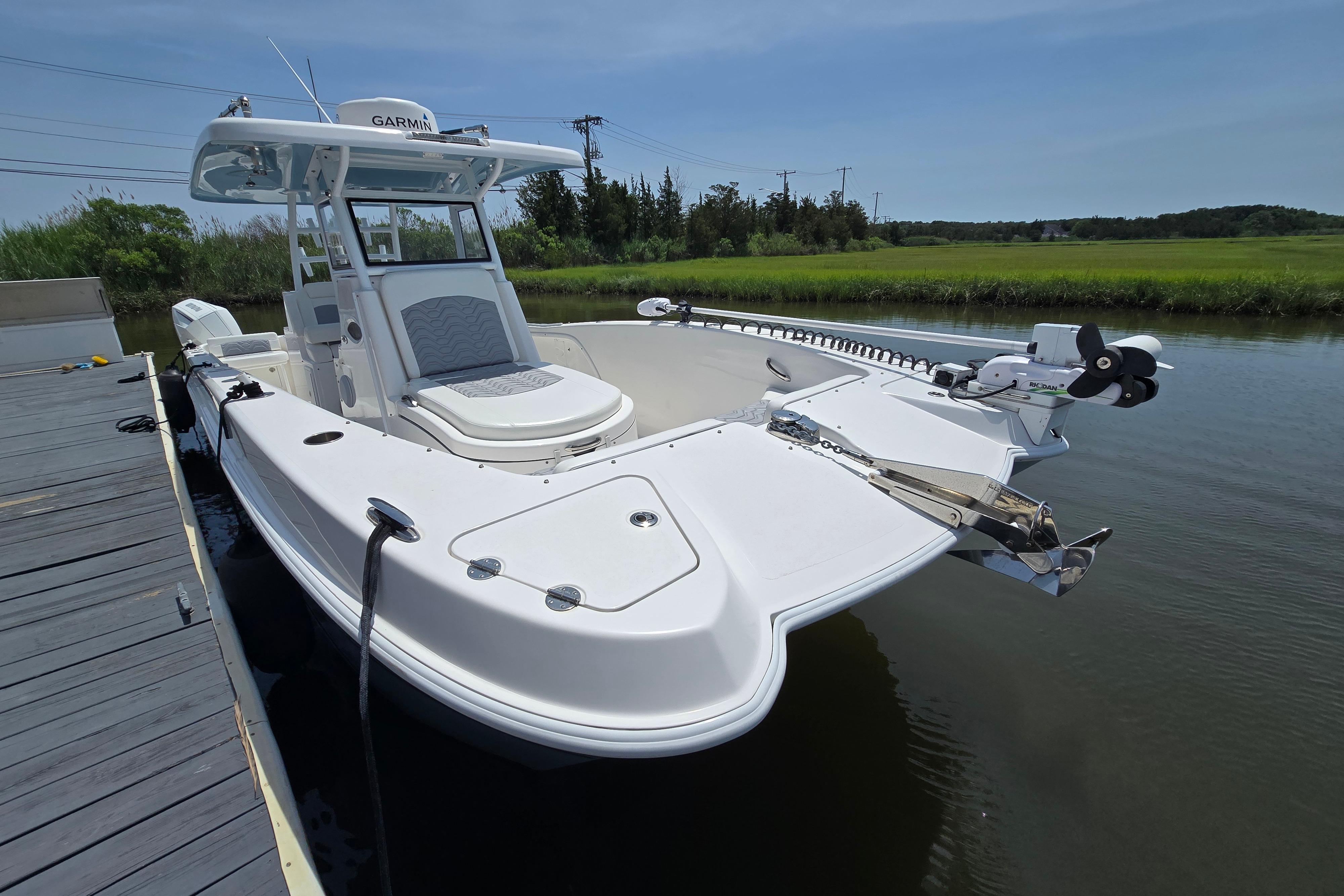 2021 Twin Vee 280 GFX CC boat docked on calm water, featuring sleek design and modern equipment.