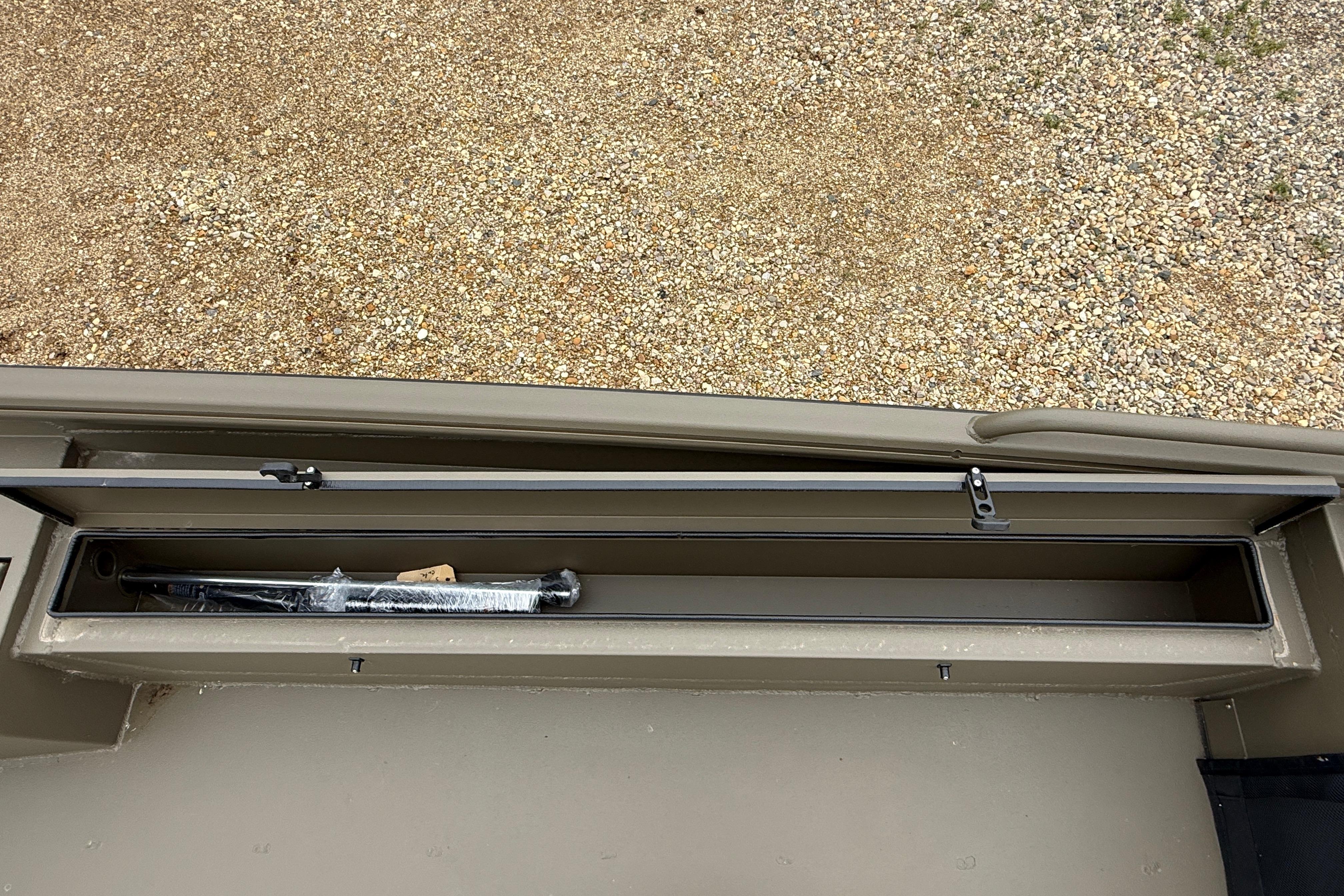 Storage compartment of 2026 Excel 1860 Shallow Water F4 boat, open with contents visible.