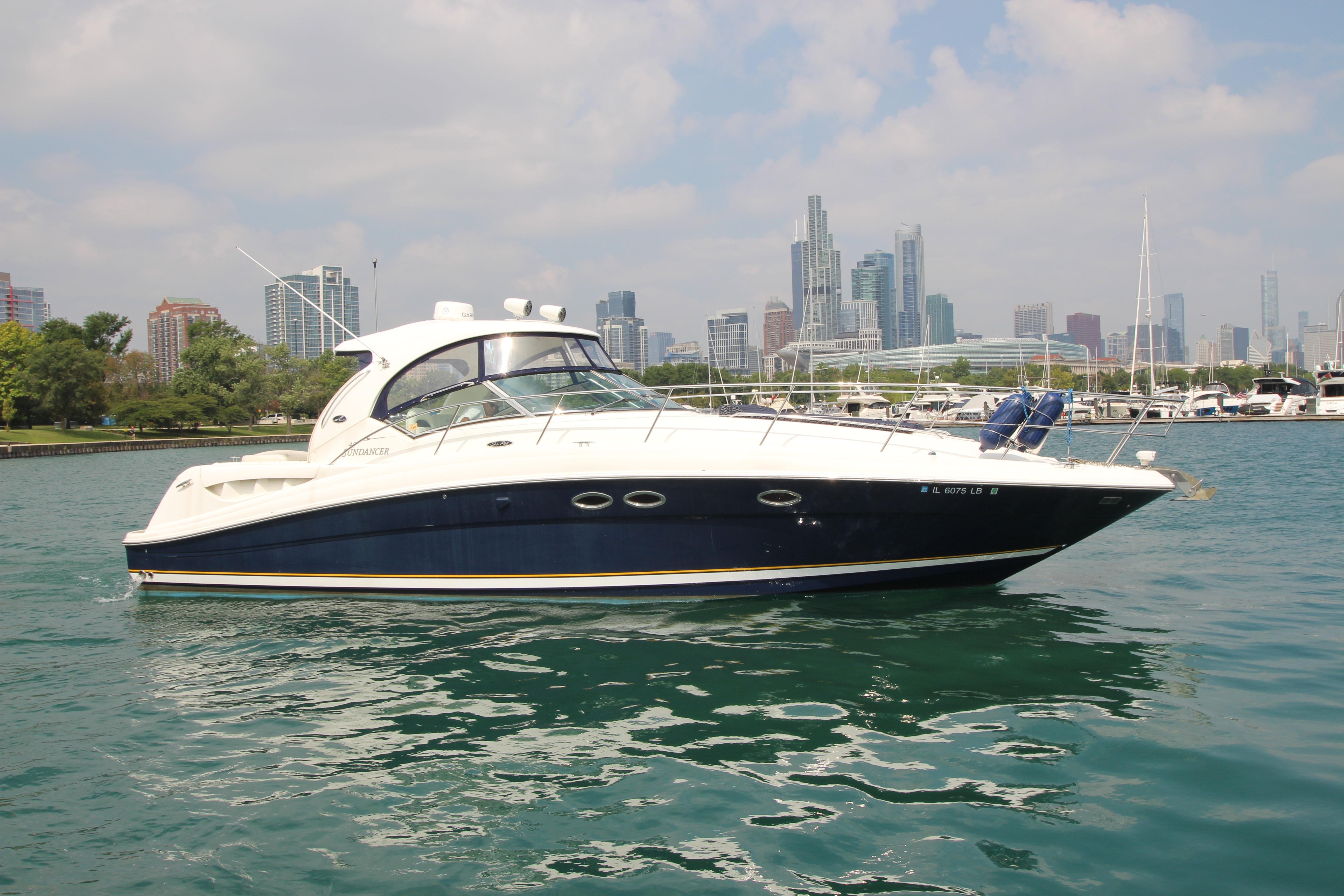 2004 Sea Ray 40 Sundancer yacht on water with city skyline background.