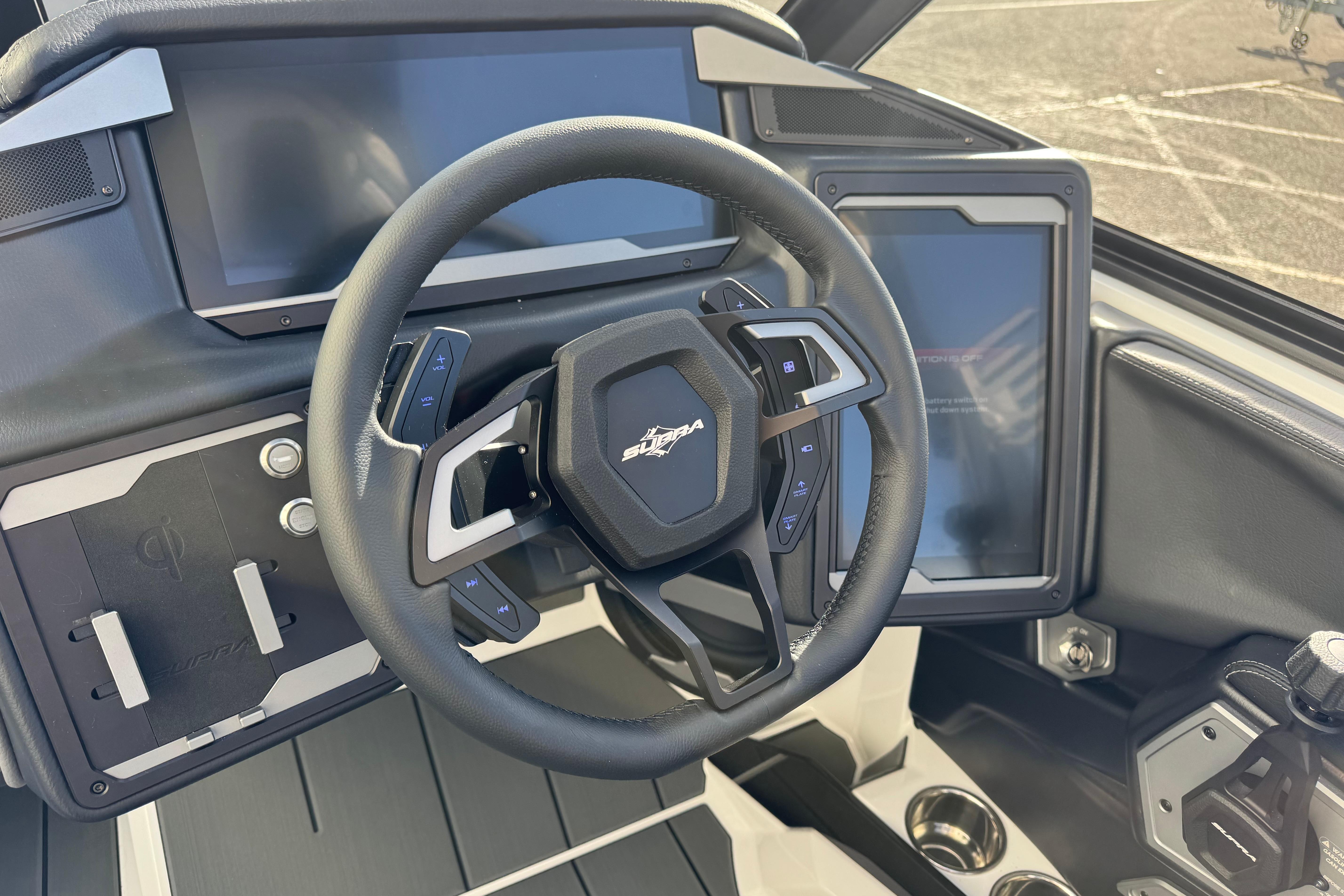 Steering wheel and dashboard of 2026 Supra SA 575 boat, featuring modern controls and displays.