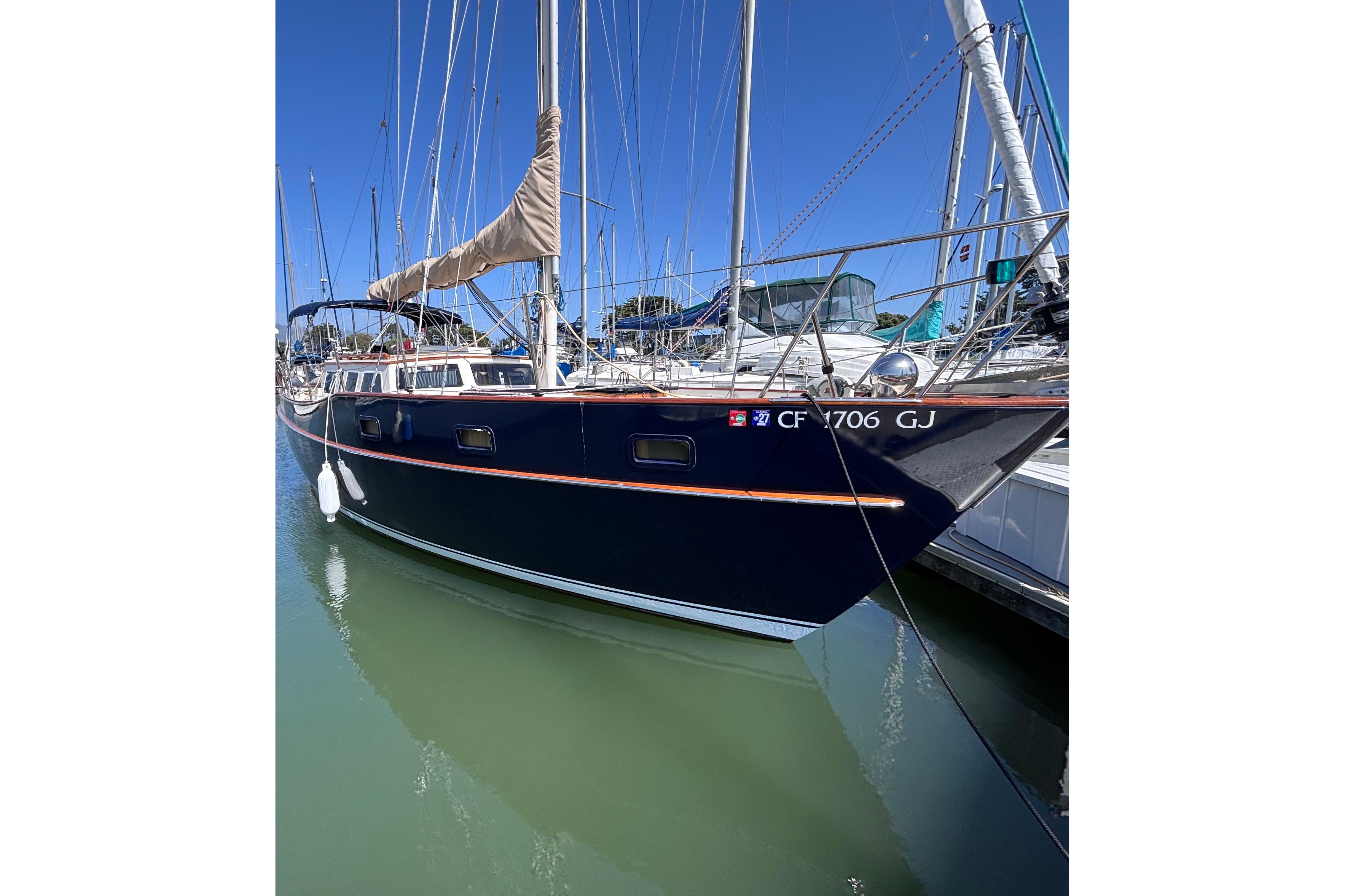1978 Swift 33 sailboat docked in marina, featuring sleek design and blue hull.