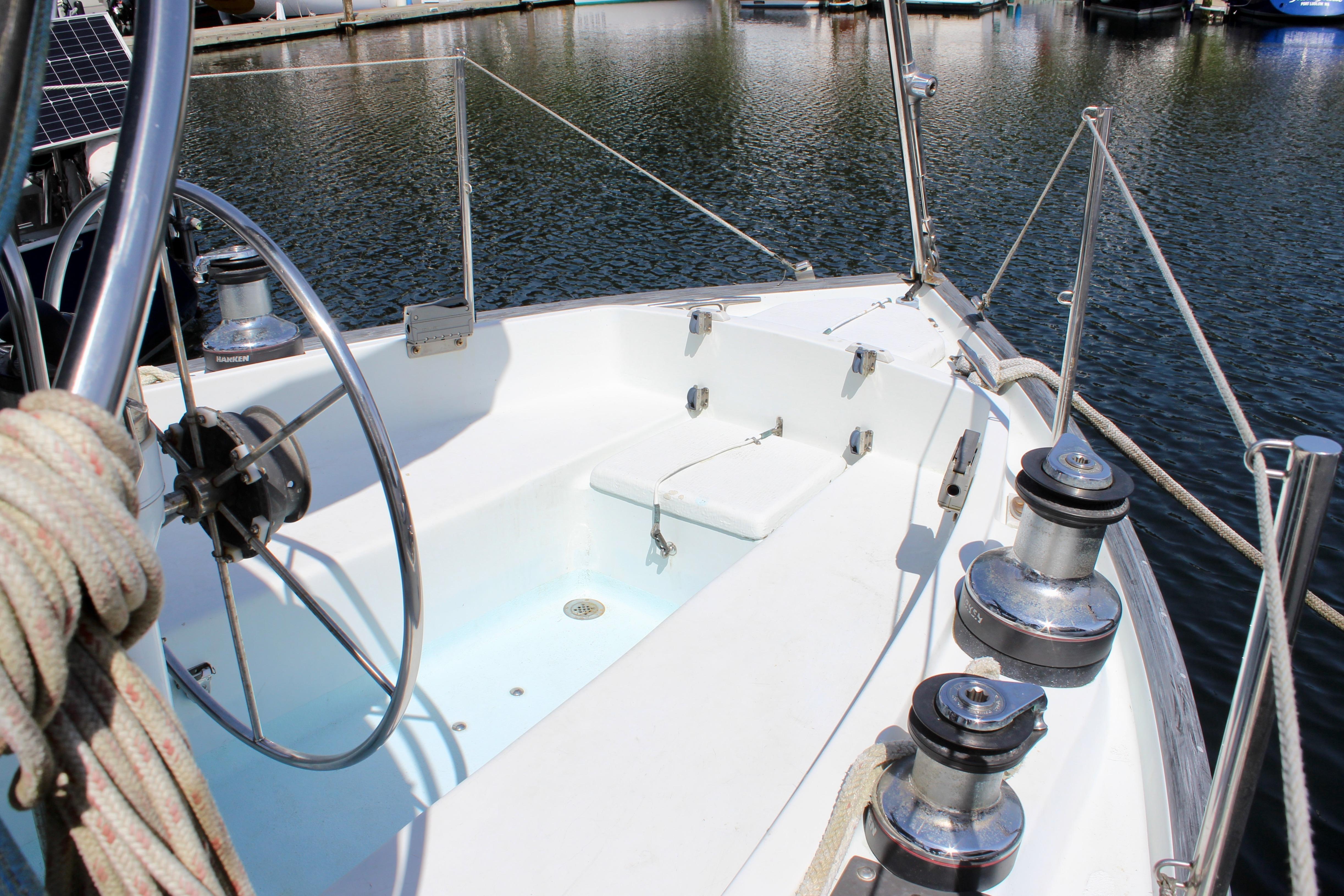 Cockpit of 1993 Freya 39 sailboat with steering wheel and winches, docked in marina.