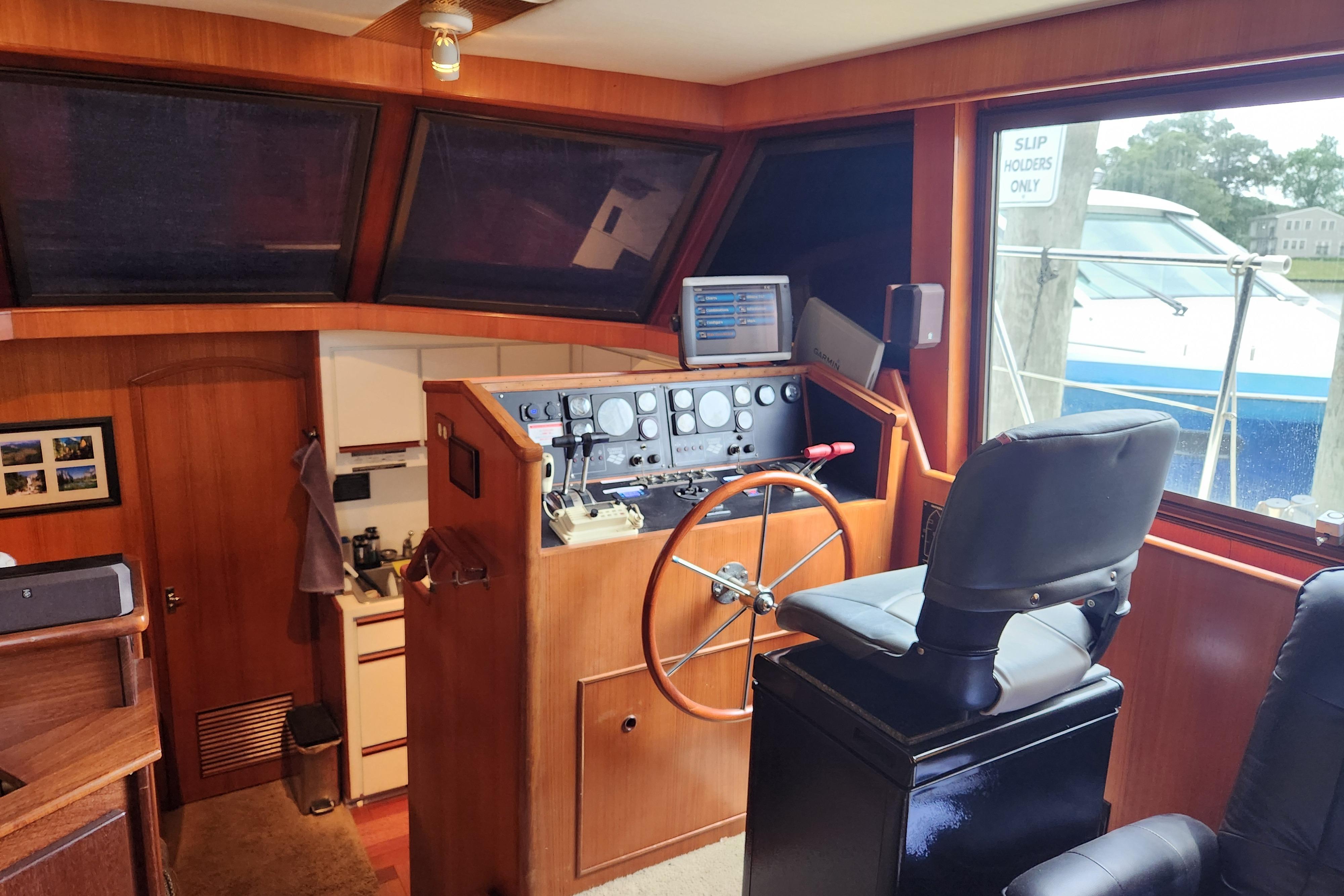 1989 Hyatt Double Cabin Motoryacht helm with steering wheel, control panel, and captain's chair.