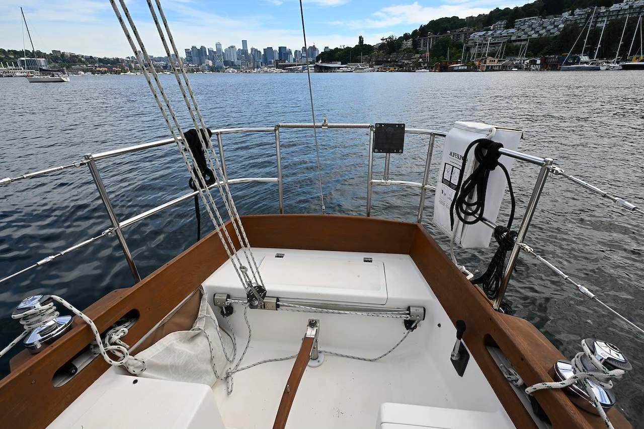 1977 Mercator Offshore sailboat deck with city skyline and marina in the background.