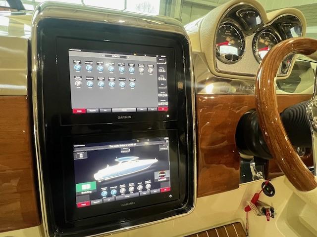 2021 Chris-Craft Launch 35 GT dashboard with Garmin displays and wooden steering wheel.