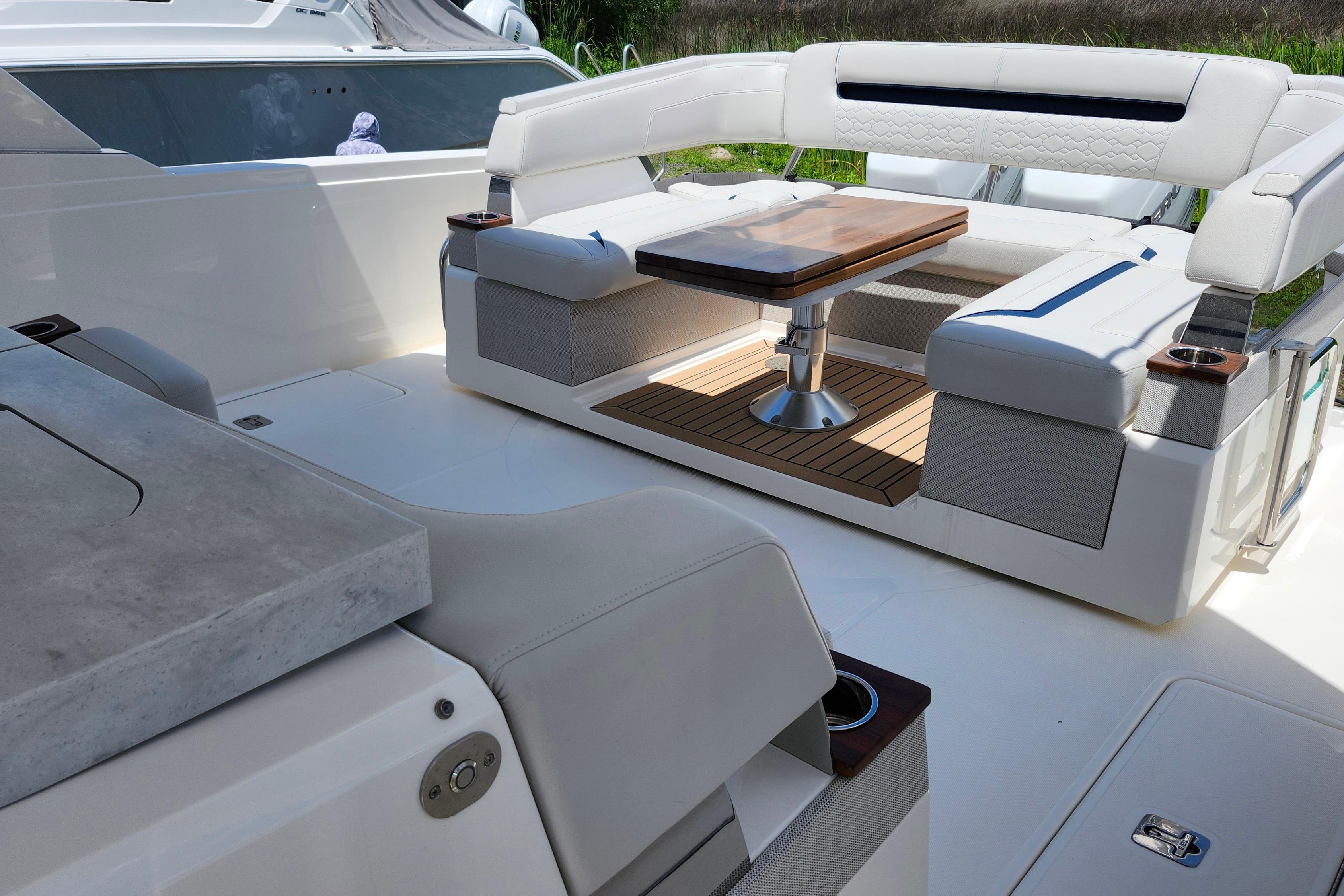 2022 Tiara Yachts 38 LS luxury seating area with elegant table and cushioned seats.