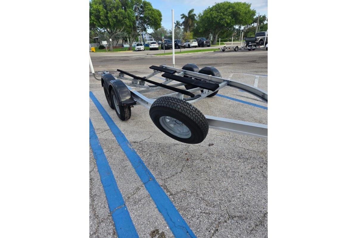 Trailer for 2024 Yamaha Boats 222 FSH Sport E in parking lot.