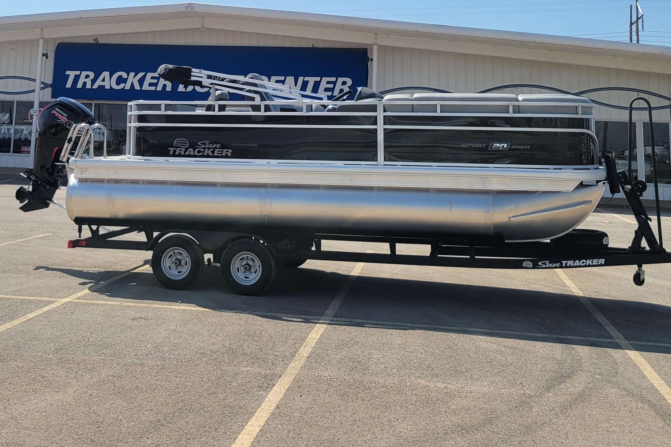 2026 Sun Tracker SportFish 20 DLX pontoon boat on trailer at dealership.