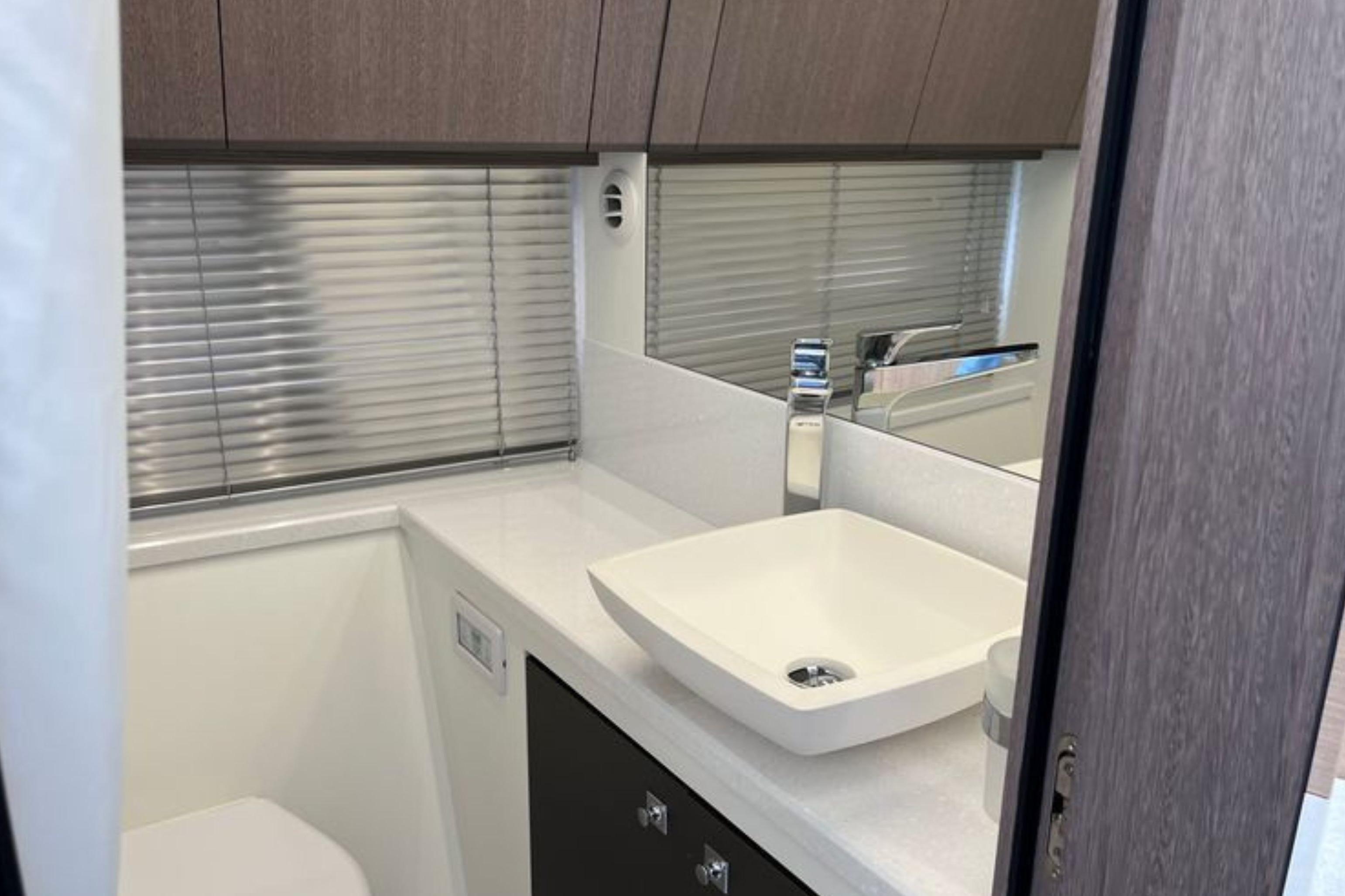 Modern bathroom interior of 2024 Galeon 425 HTS yacht with sleek sink and cabinetry.