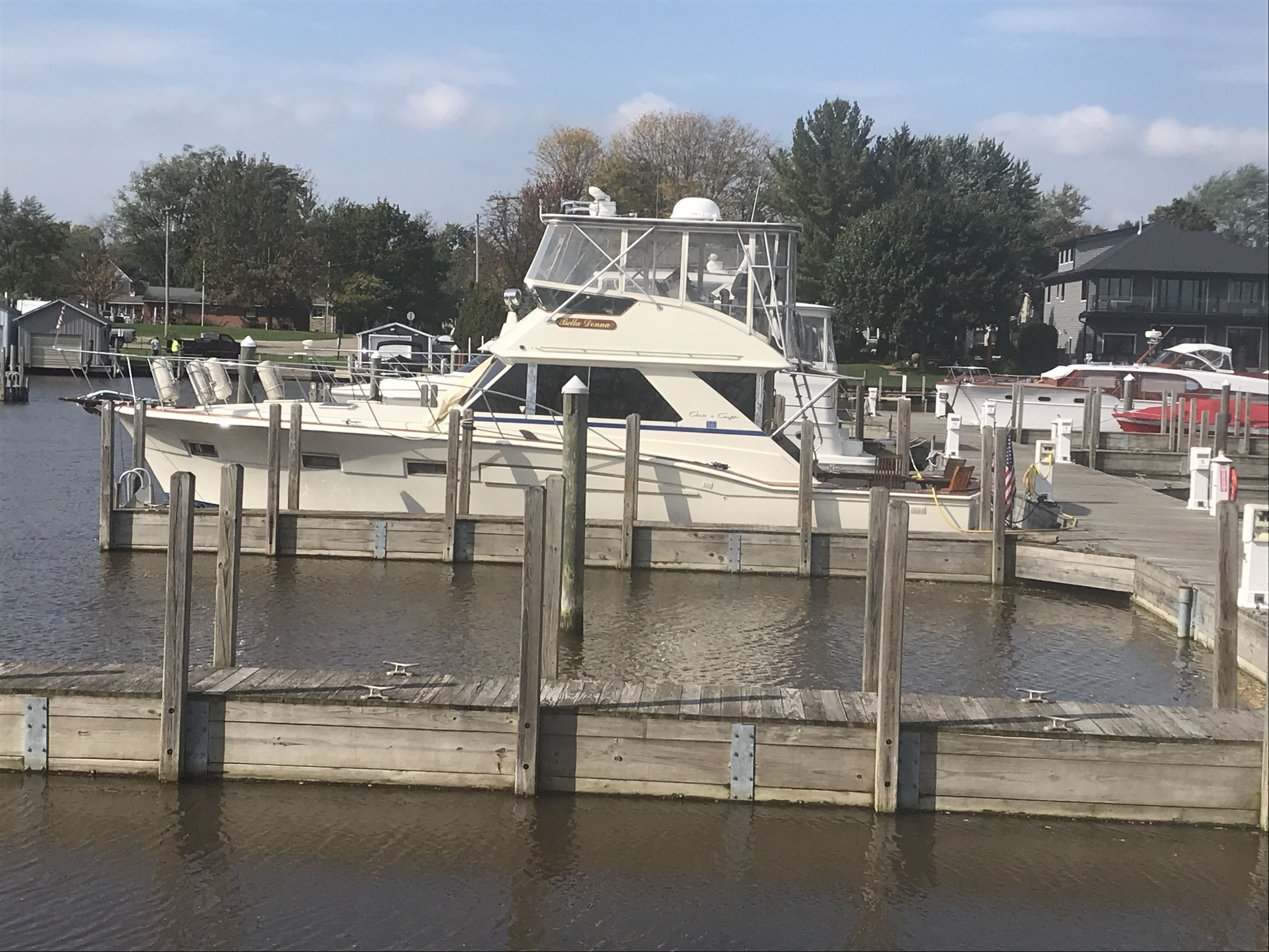 1979 Chris-Craft 45 TF docked in a harbor, surrounded by calm water and piers.