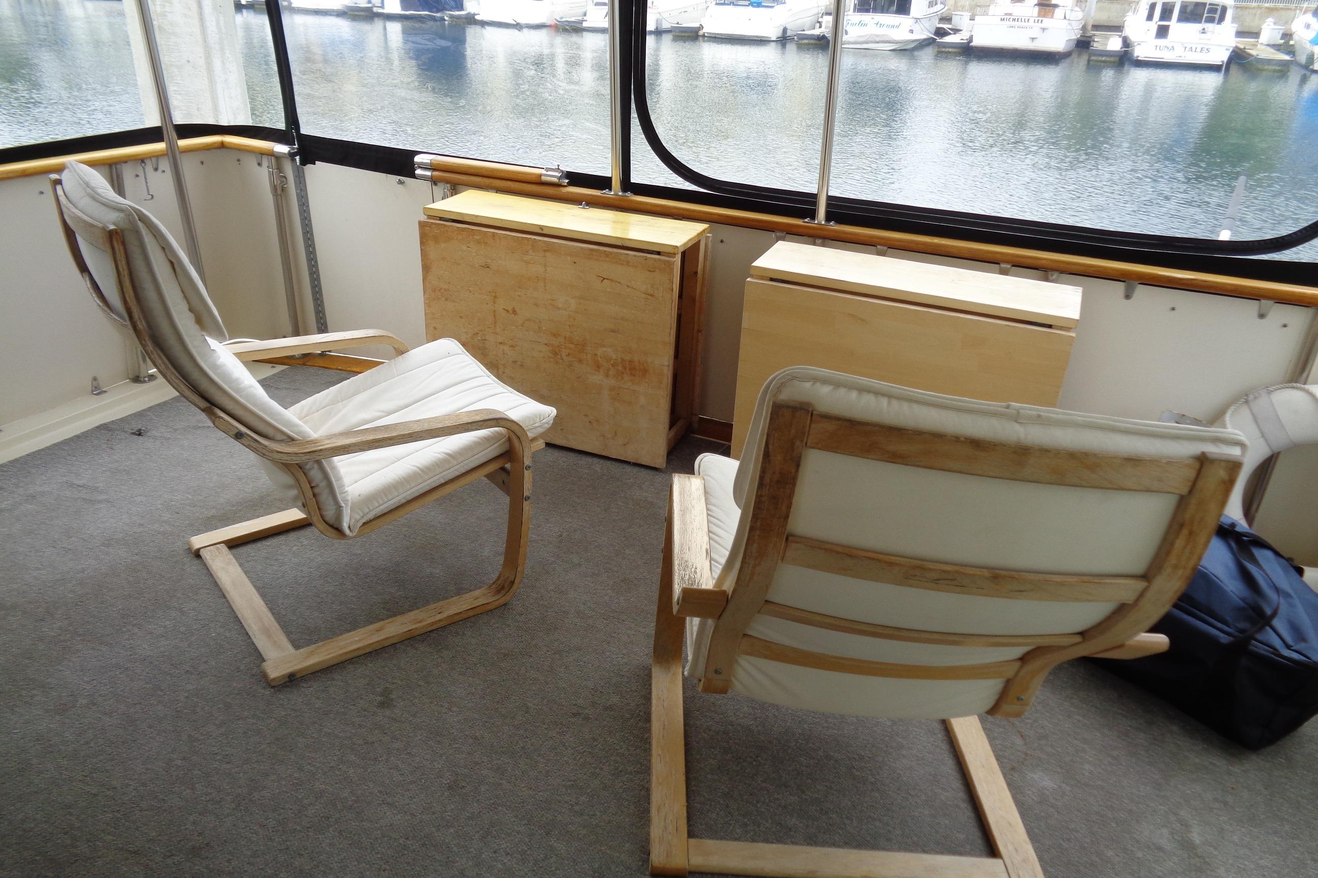 Interior of 1981 Hatteras 48 Cockpit Motor Yacht with chairs and wooden cabinets. Sun Deck