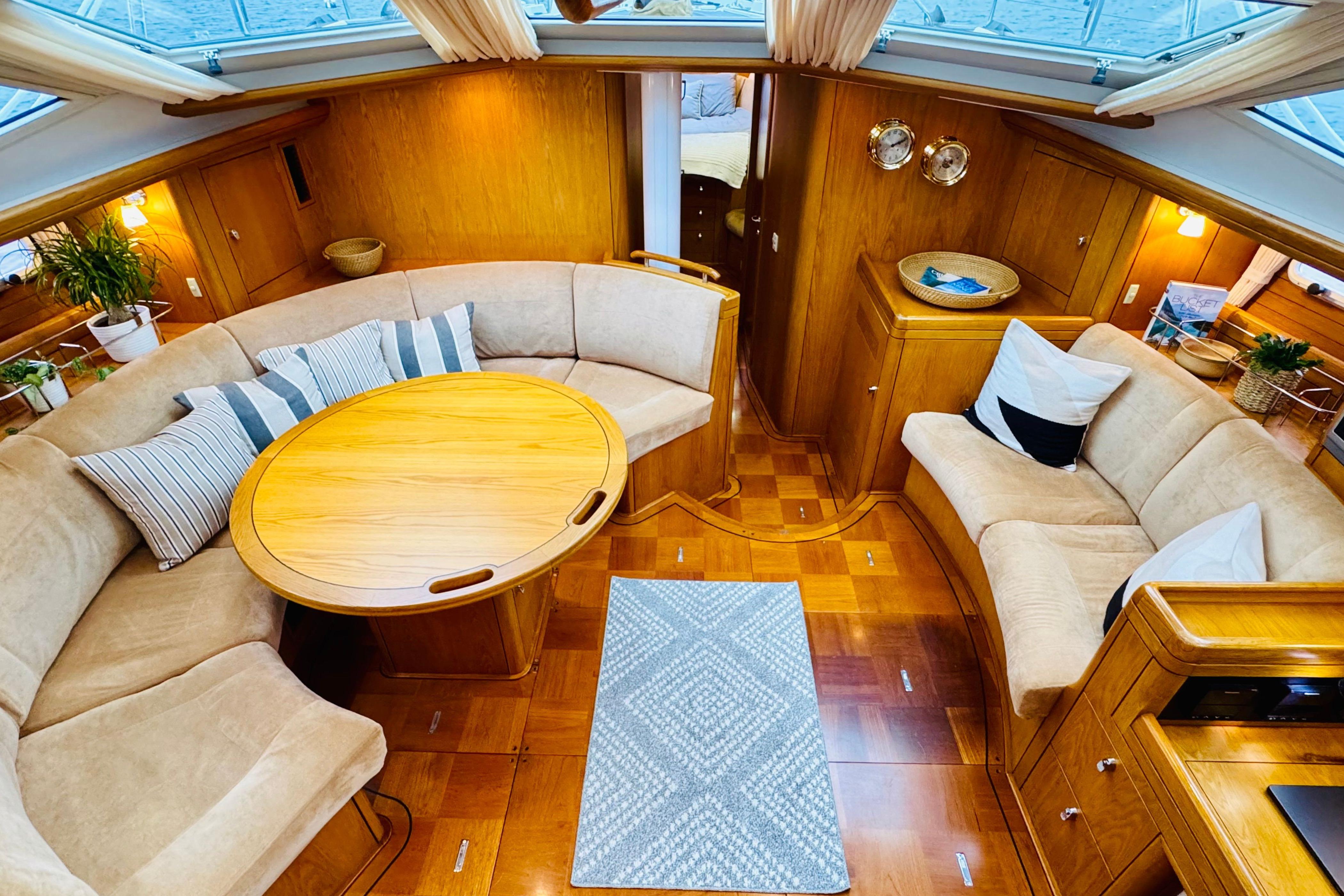 Luxurious interior of a 2005 Oyster 56 yacht with elegant wood finishes and cozy seating.