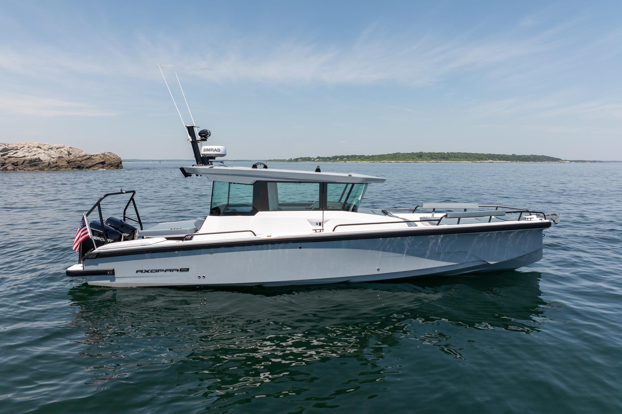 2026 Axopar 29 XC Cross Cabin boat on calm water, clear sky background.